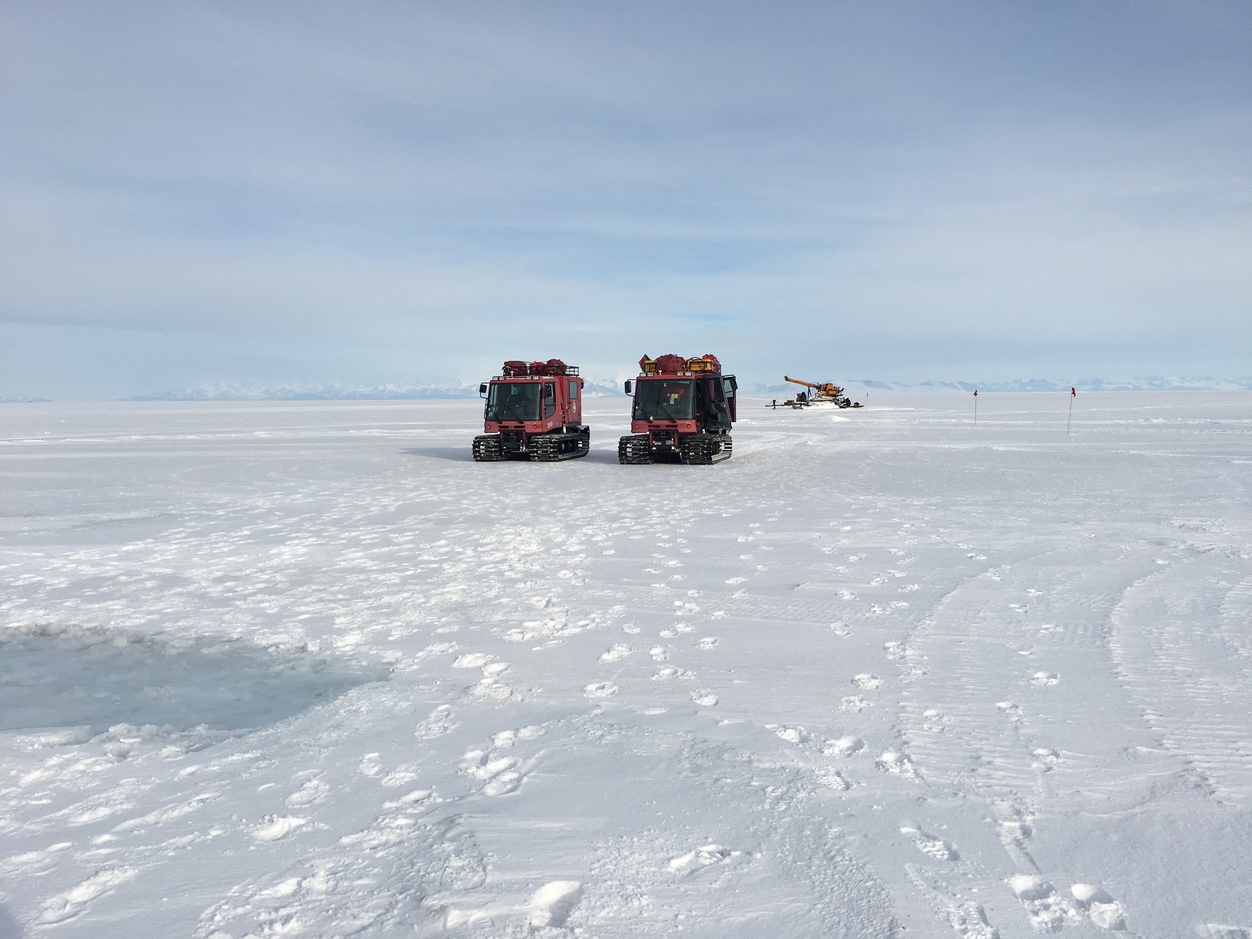  Two pisten bully on the ice with the drill rig in the background. 