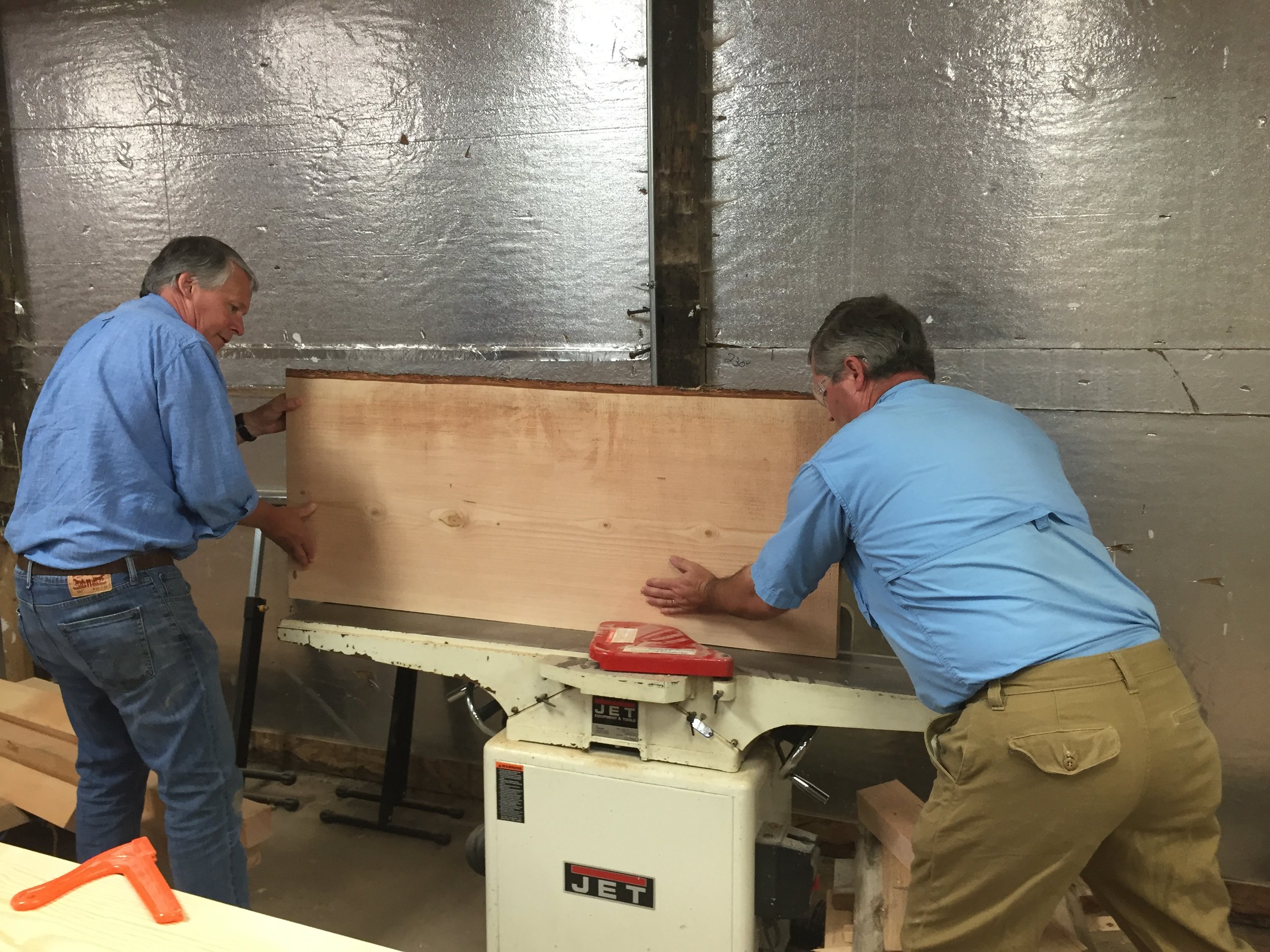  We provided the desk and table tops for Port Blakely, but the bases of the desk and meeting table were constructed by another company. For this project, my dad and I learned how to joint the wood. In this picture, our good friend Cort is showing my 