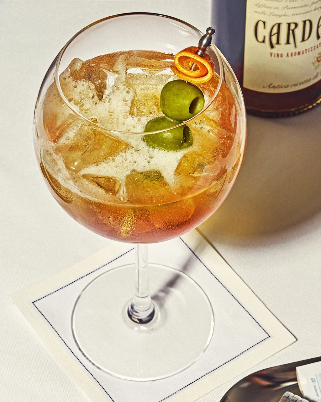 editorial beverage photo of a spritz cocktail with olives / shot by commercial food photographer Ali Redmond