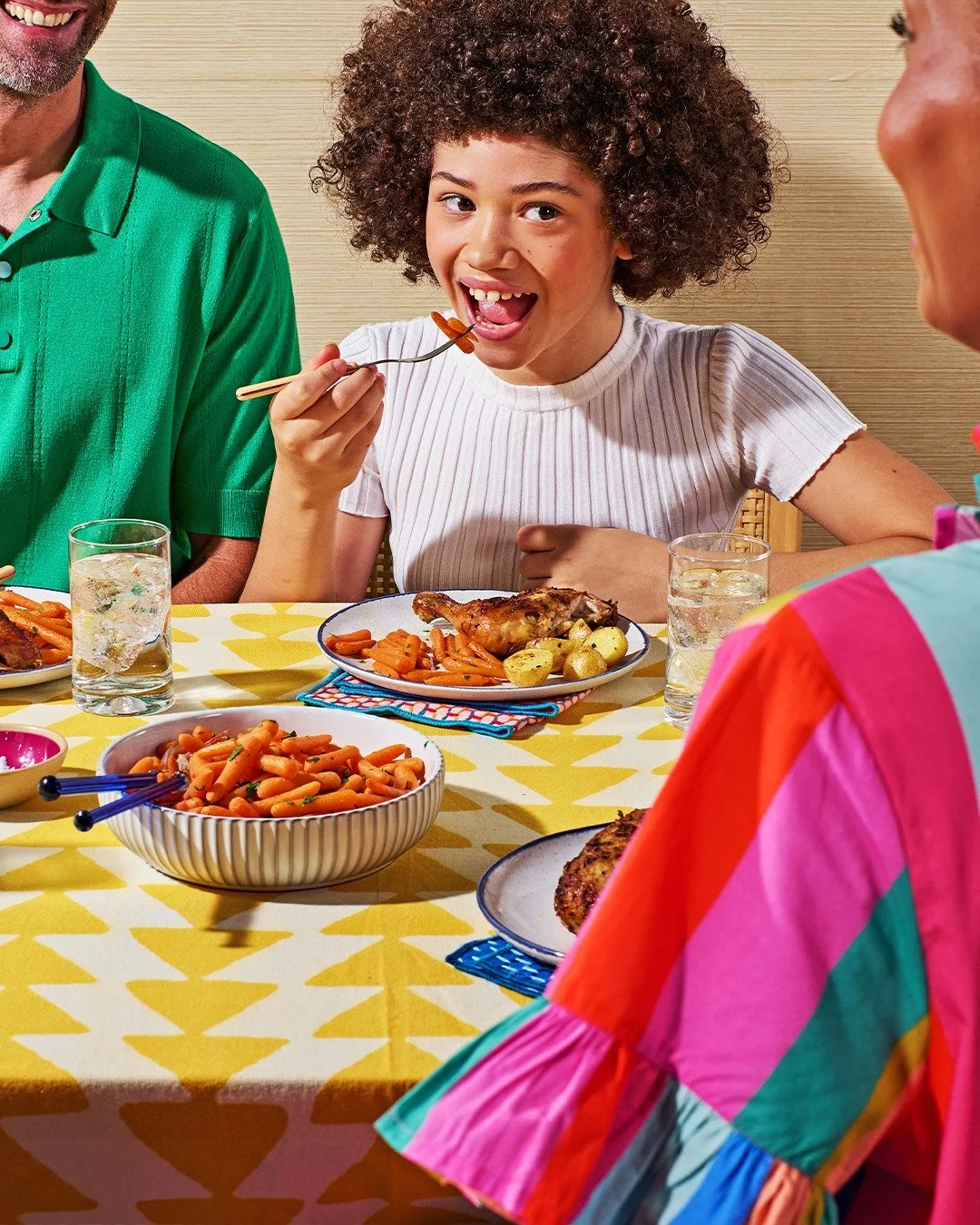 Commercial photography of a young teen sitting with her family eating a meal
