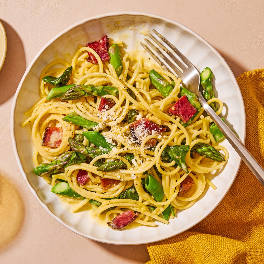 Commercial photography of a plate of pasta with asparagus and bacon