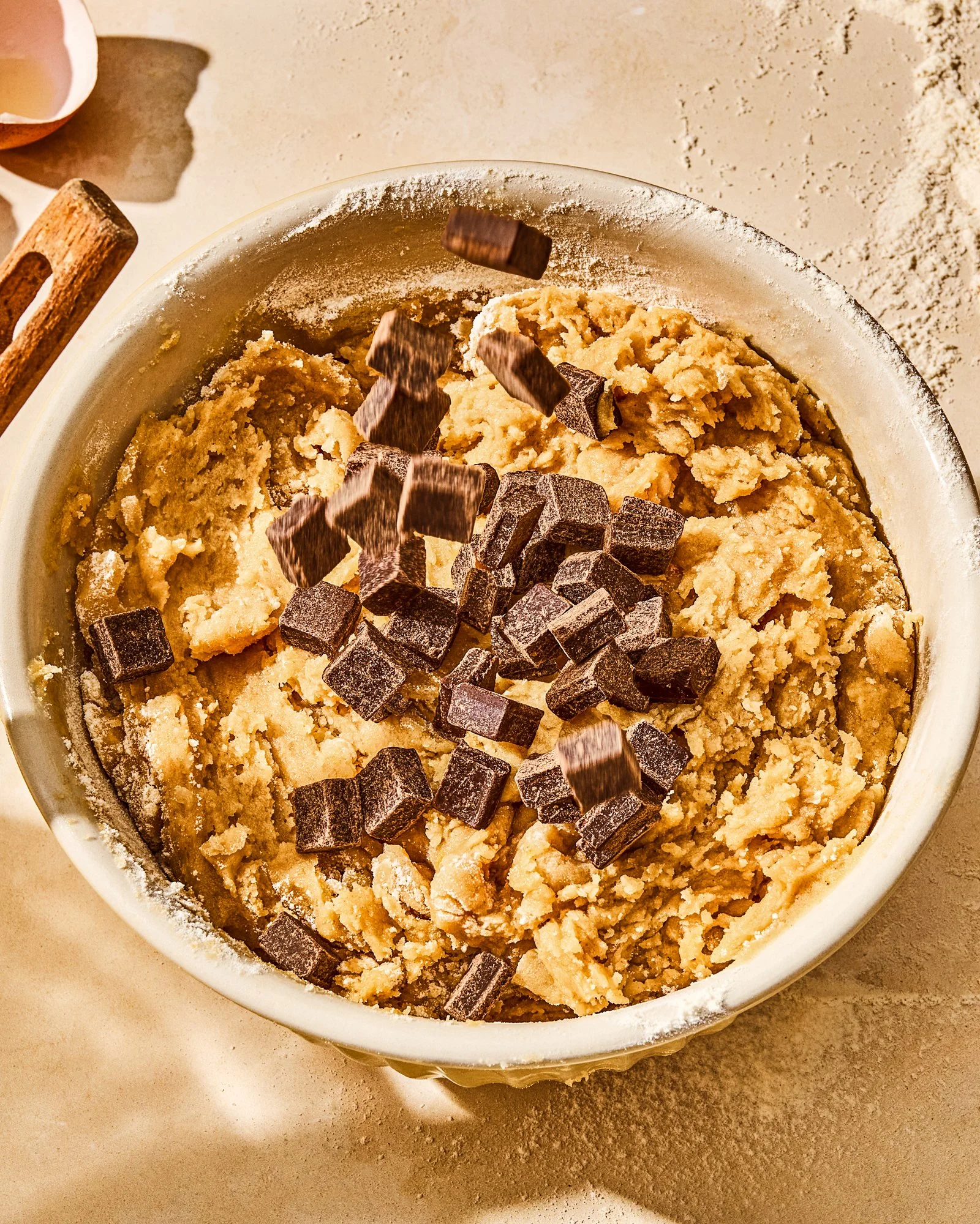 Commercial photography of a bowl of cookie dough with chocolate chips falling in