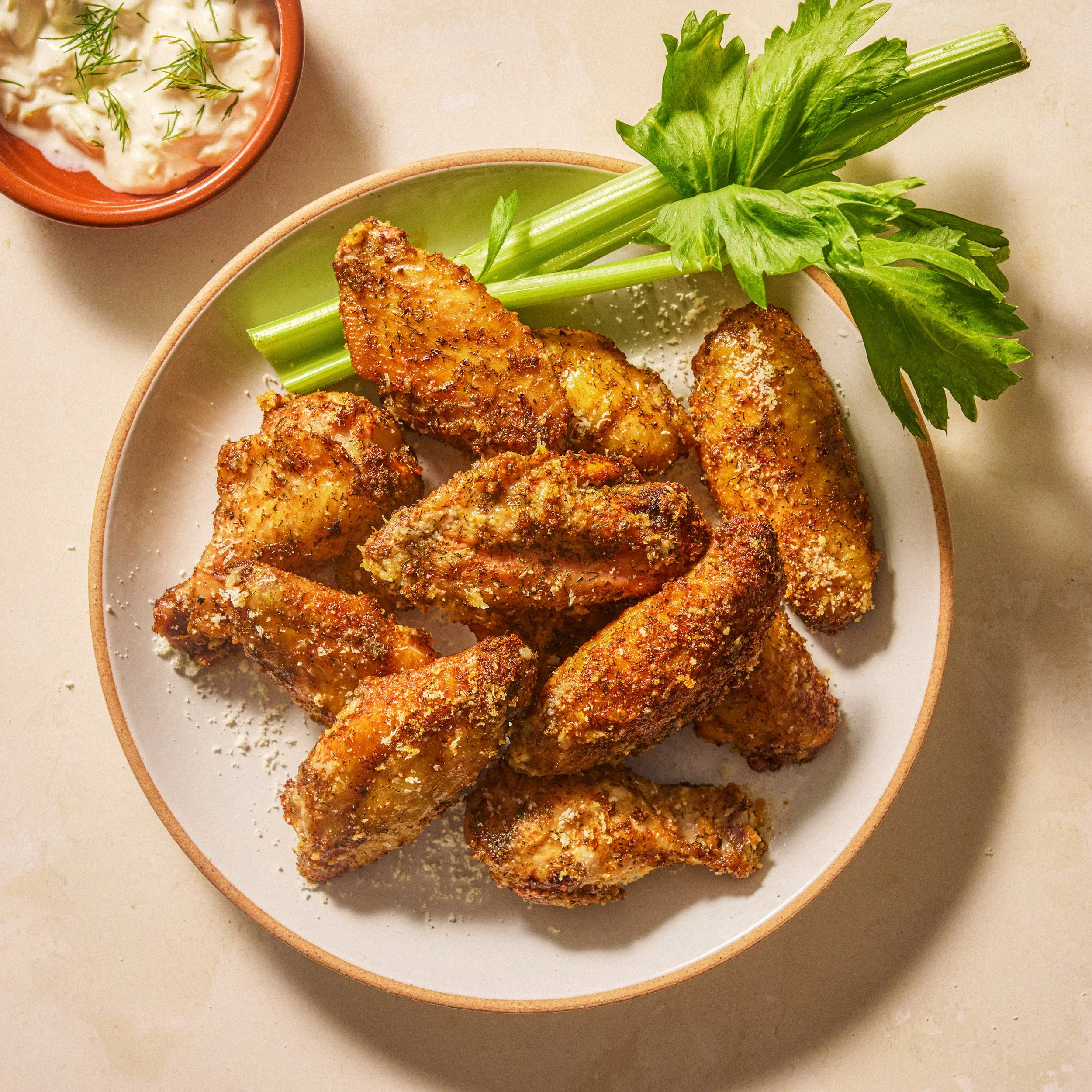 Crispy dry-rubbed baked chicken wings with parmesan or seasoned breadcrumb coating, served with celery and creamy dill dipping sauce — crispy chicken wing recipe, dry rub wings, game day appetizer pepperoncini dill