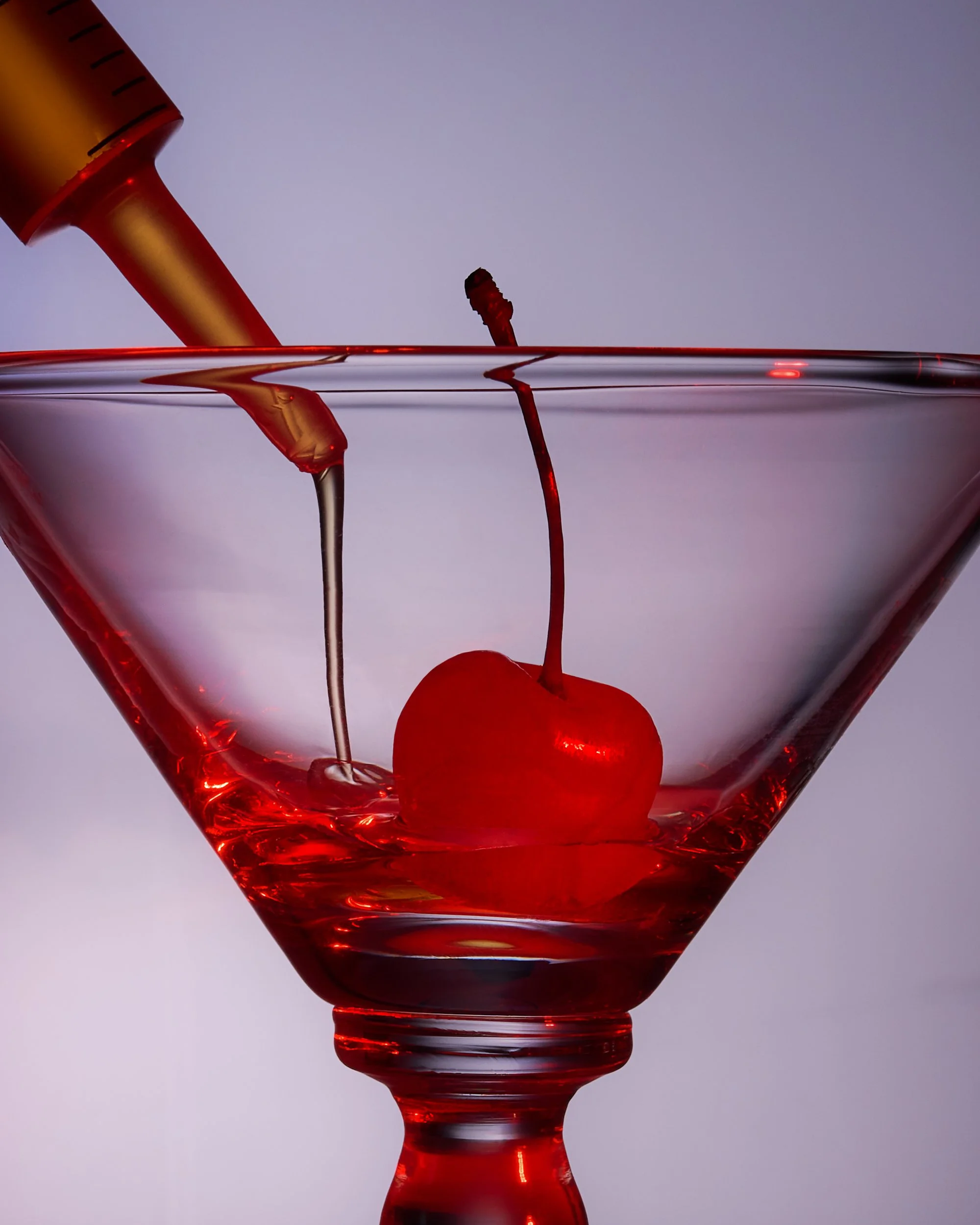 Editorial cocktail photography of a cherry and syringe of alcohol shot by food and beverage photographer Ali Redmond