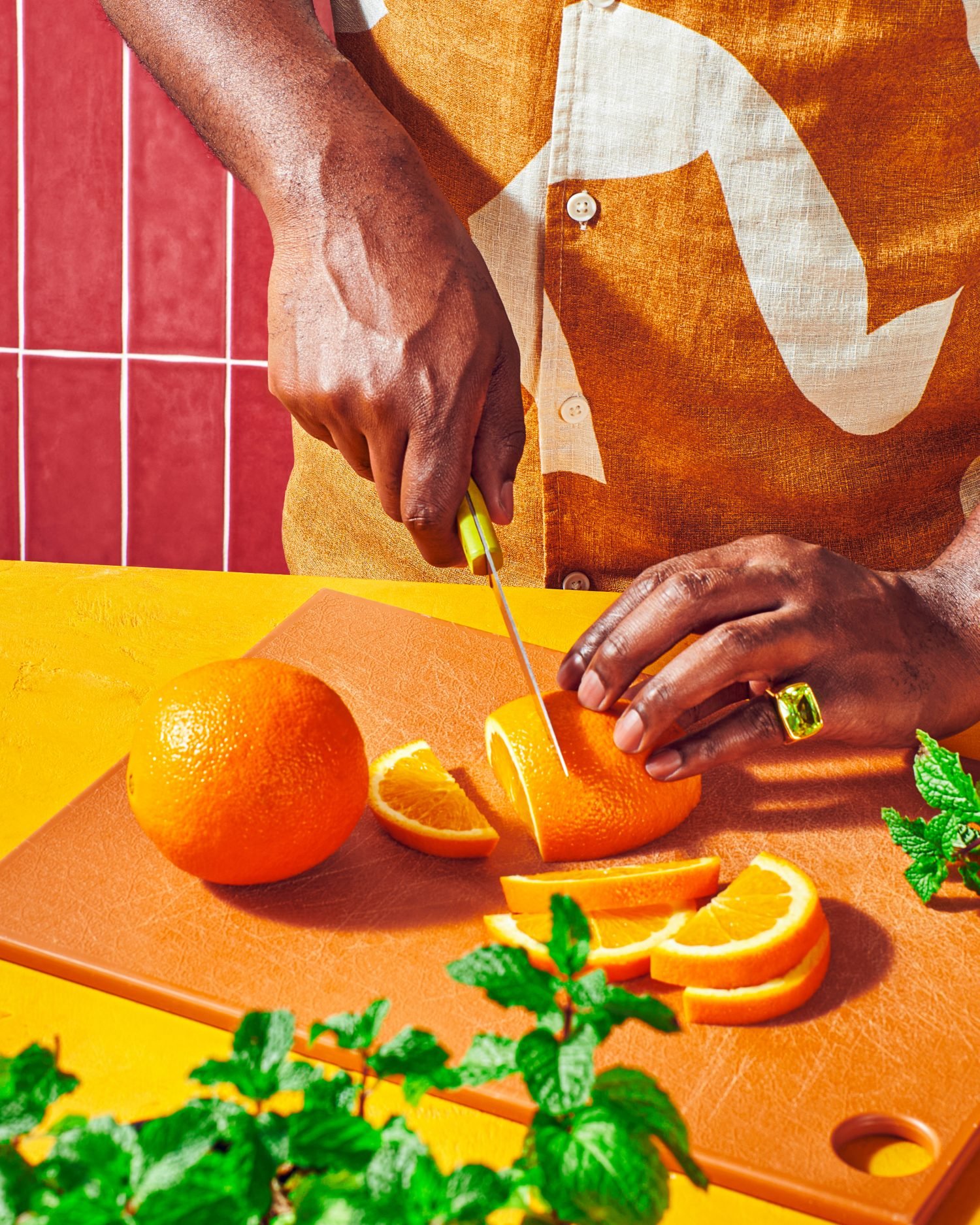 Commercial photography of a man slicing oranges on a cutting board