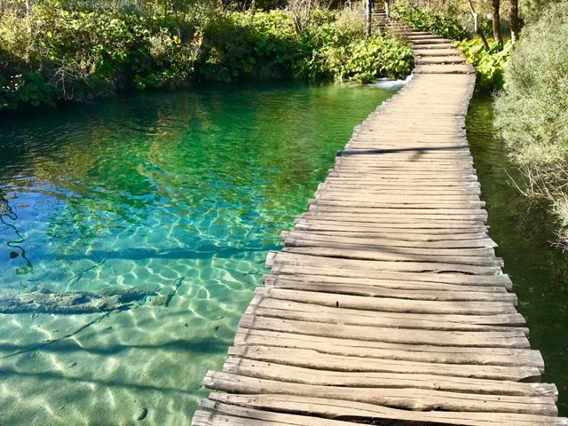 Walking over crystal clear Plitvice Lakes.
