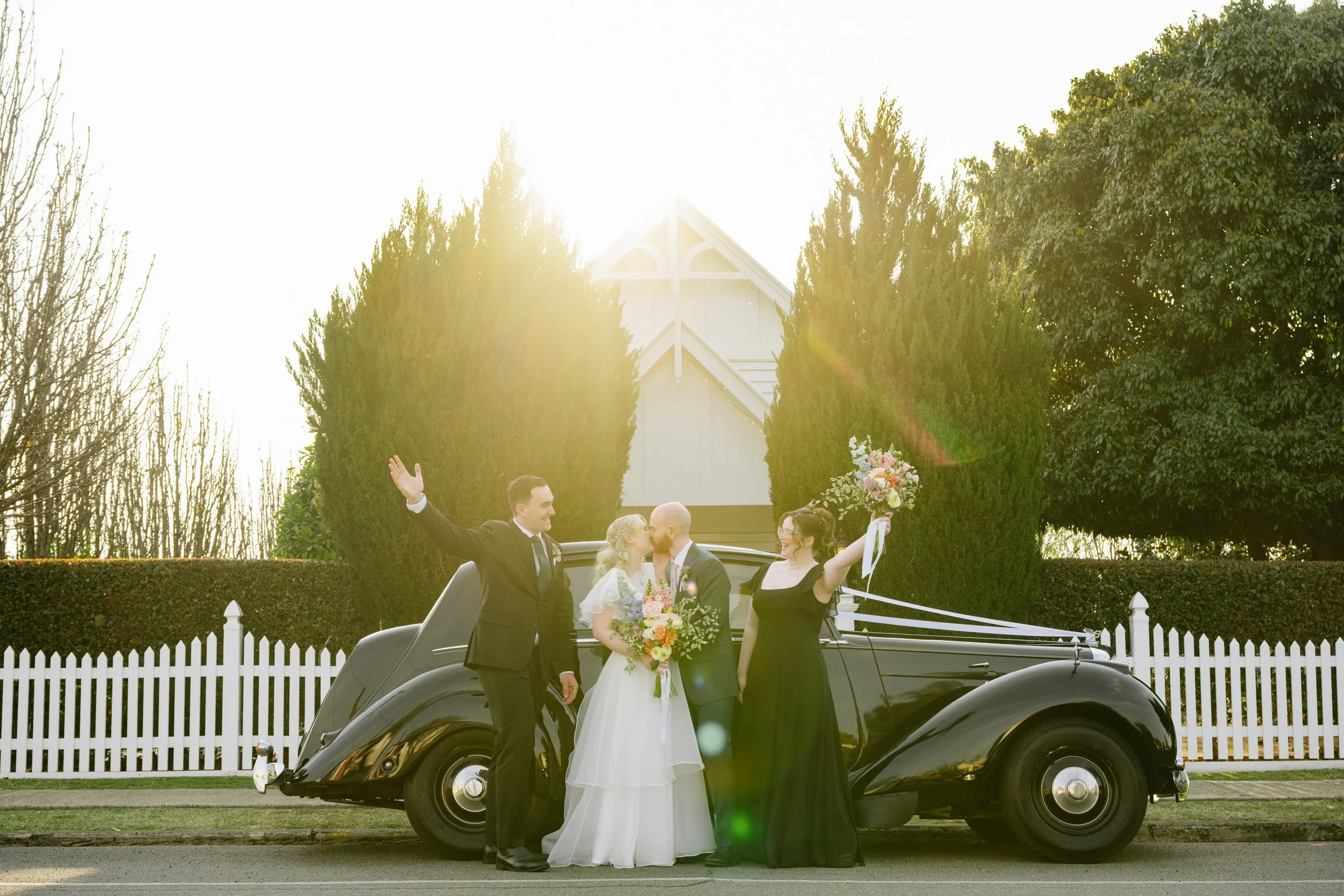 Tacha and Chris with the bridal party celebrating in front of White Chapel Kalbar