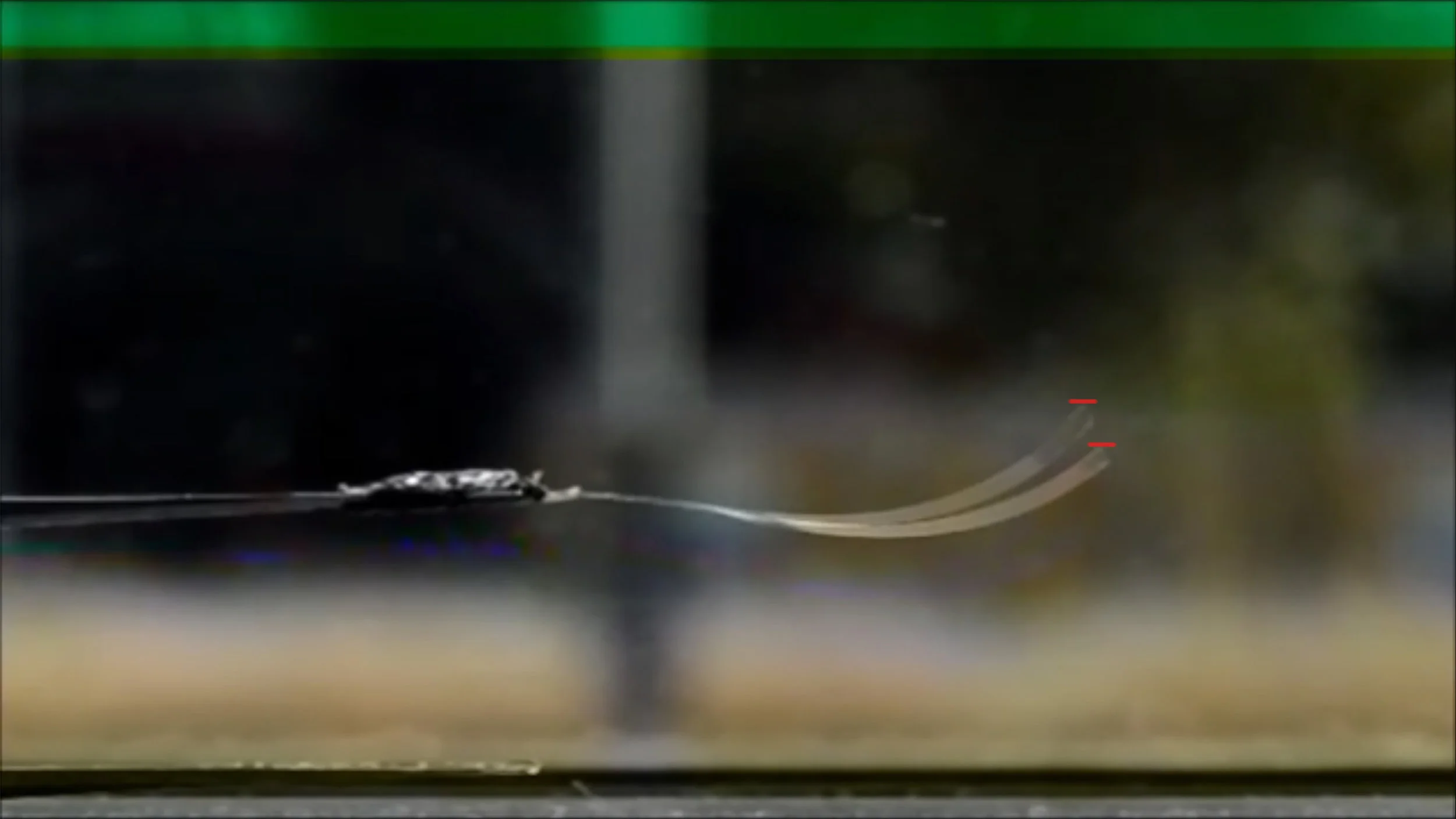 Two superimposed freeze frames of the moving actuator. The red lines illustrate the top of the position of the film at the point the video was frozen. A notable change in position can be seen. 