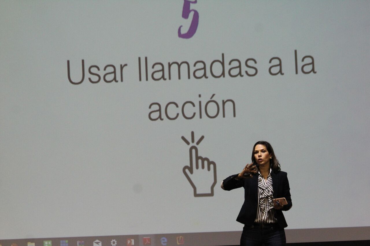 Virginia Saman de pie en frente de una pantalla que dice 'Usar llamadas a la acción' con un icono de dedo señalando