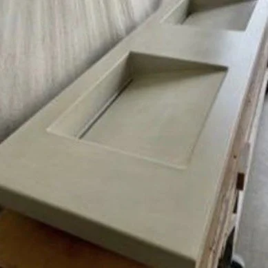 Top view left of beige Double Ramp concrete sink in manufacturing space, handcast and integral basin