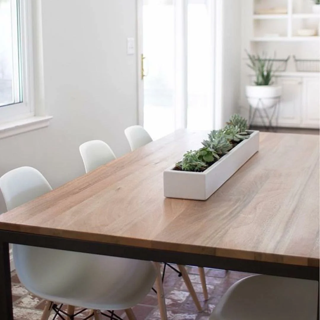 36-inch white concrete planter installed on a wooden dining table, filled with succulents, showcasing modern design in an indoor dining space