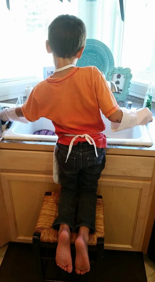 Our grandson Leo about a year ago doing dishes.