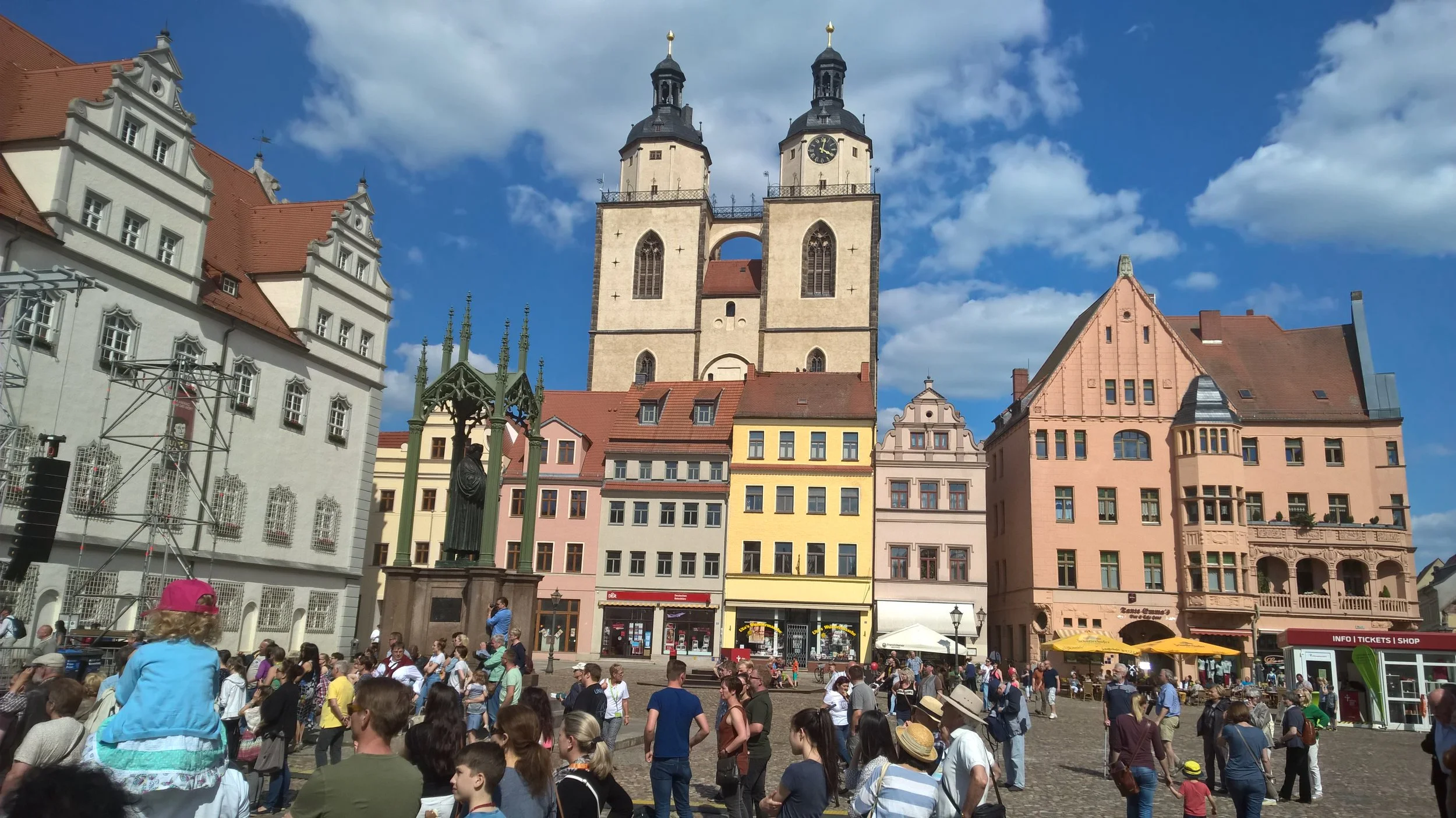 Luther's statue is on the left with his church in the center background with two spires as seen from city square as people gather for the start of the national celebration of the 500th anniversary of the Protestant Reformation.