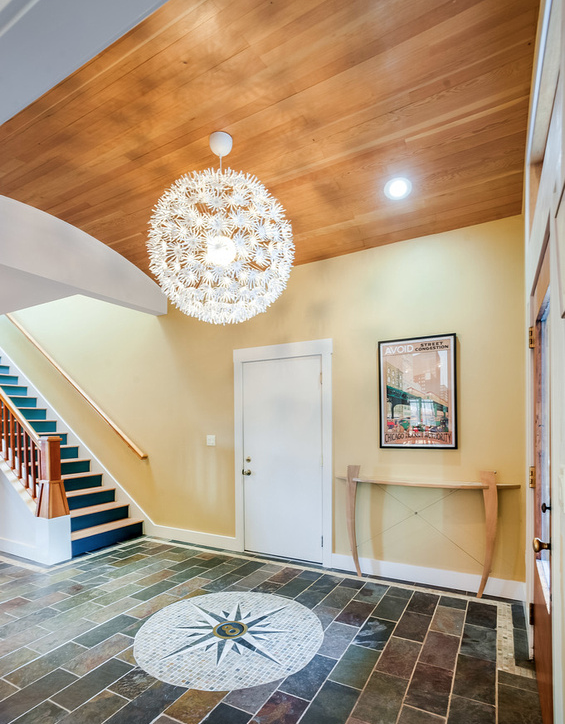 The curved roof of the porch entry continues inside with an IKEA ceiling fixture of flowers.
