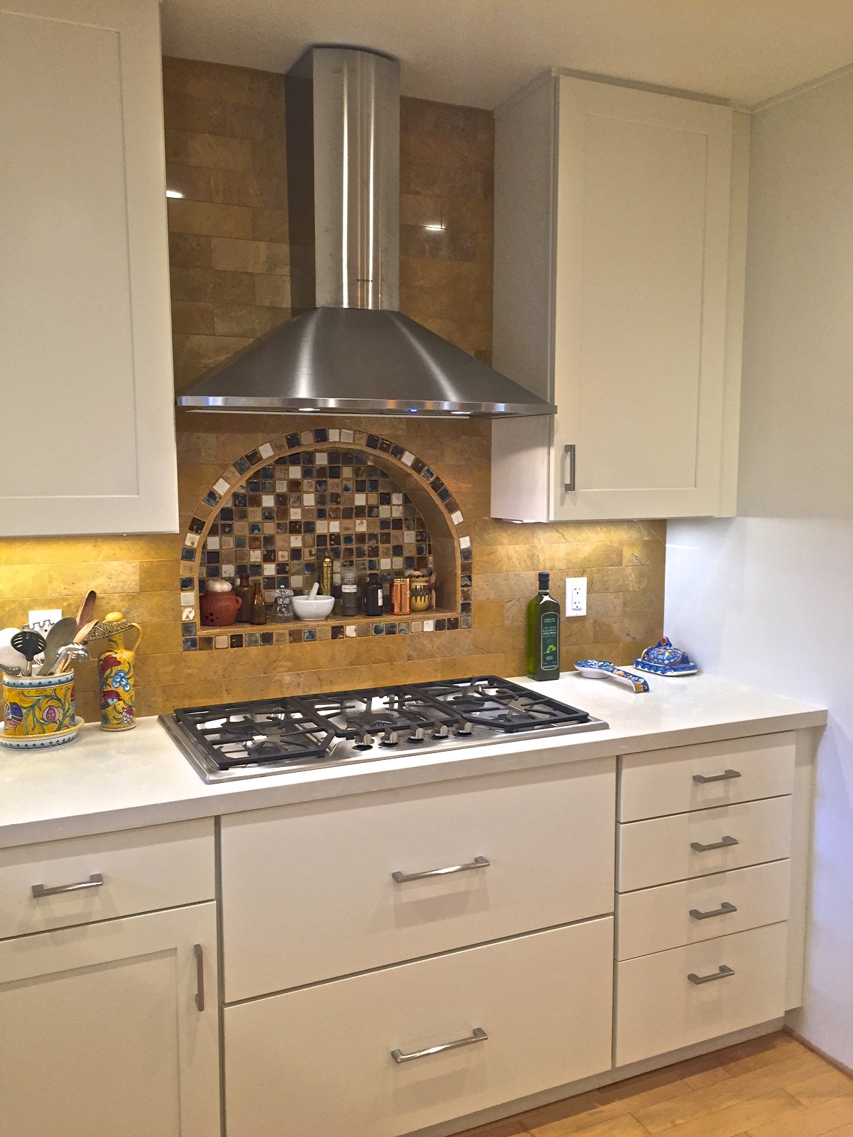 Recessed niche behind gas cook-top focuses the heart of the kitchen to the cooking area.