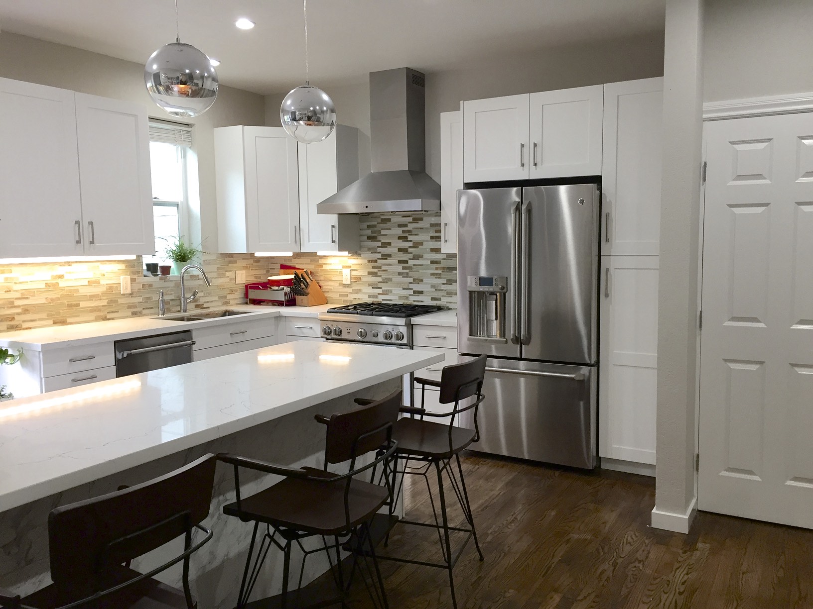 Here is the new kitchen that opens up to the entry with new wood flooring throughout.
