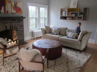  Using beloved existing seating, we transformed this family's living room by adding elements of textural beauty and pops of color. Cozy-chic Moroccan rug from Anthropologie and sheepskin throws from Ikea, Color-blocked "Tetra Flat" shelving from Brav