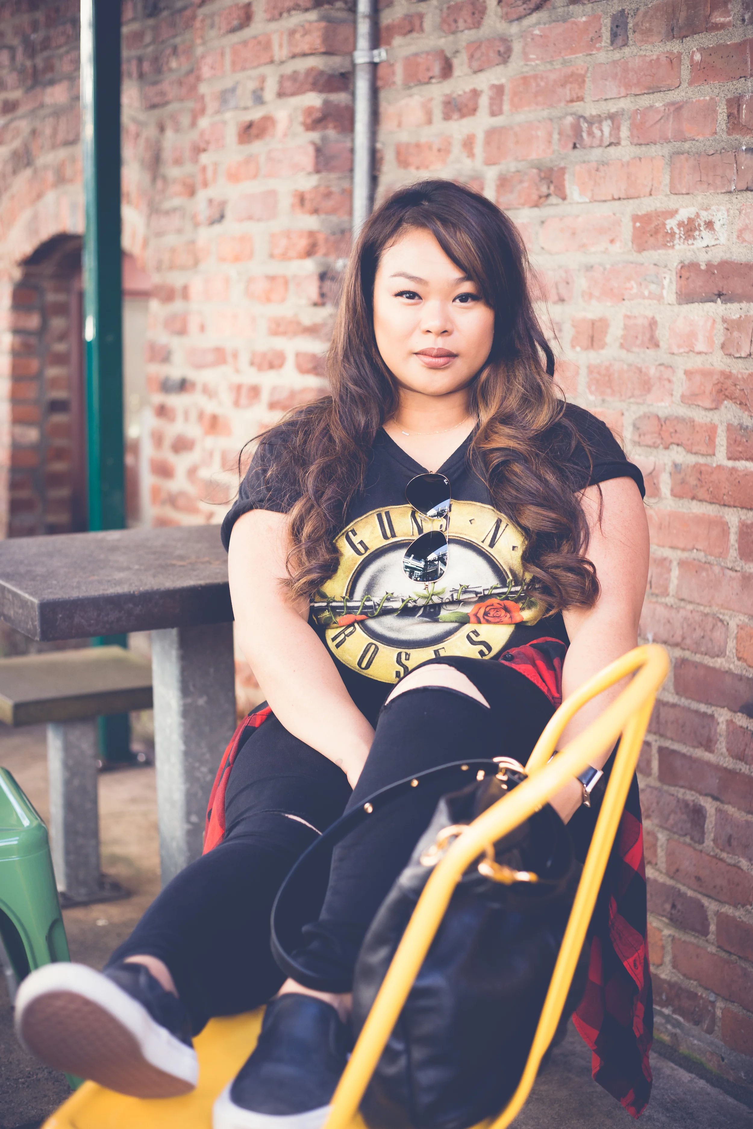 Street vibes against a cool brick wall. I love how the yellow chair compliments her t-shirt design. 