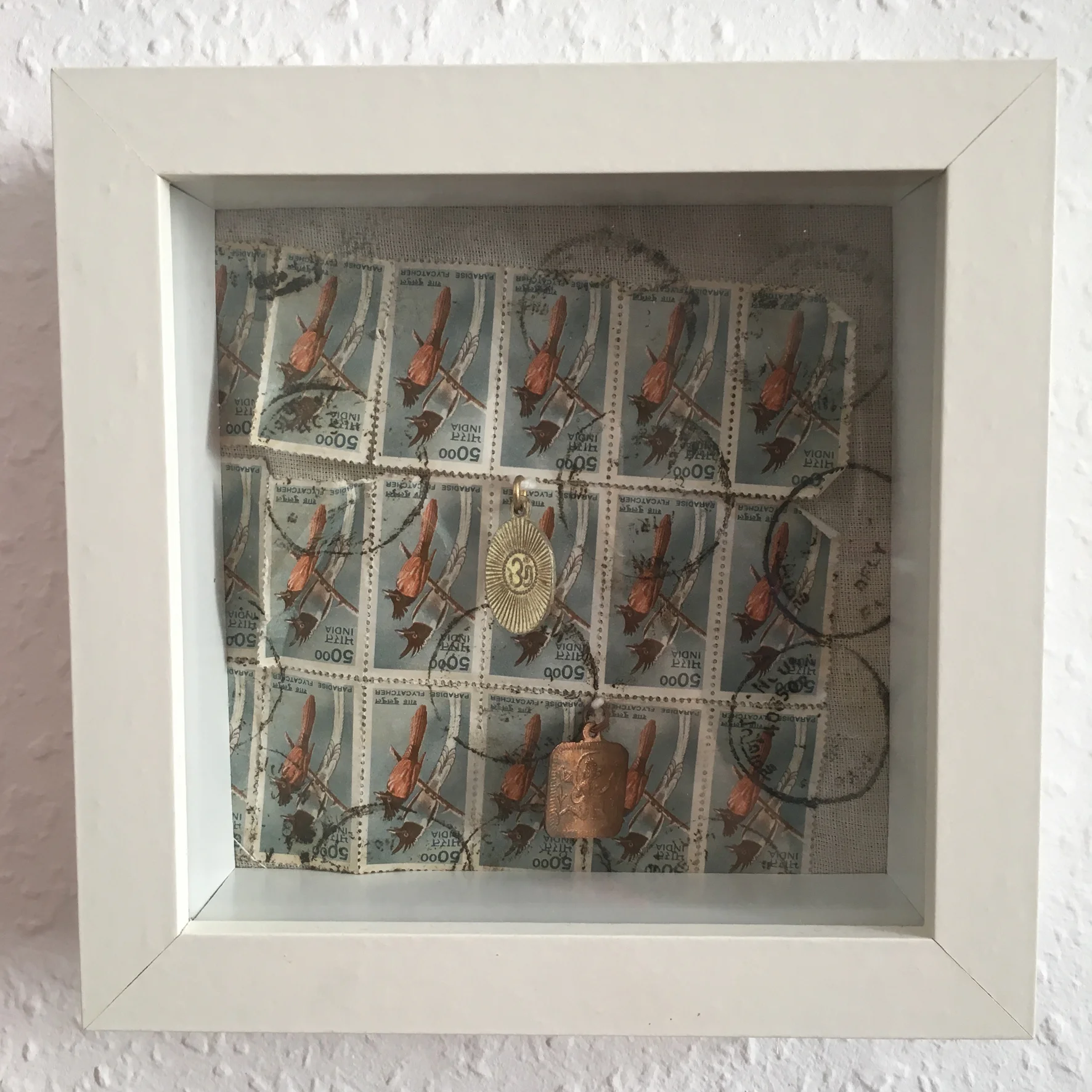 Collage with indian stamps on cotton and brass idols.