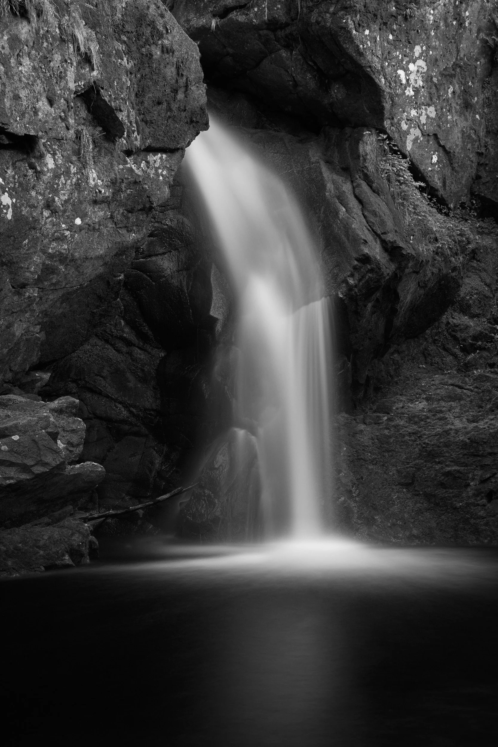 A black and white long exposure photograph of a waterfall in the Scottish highlands.