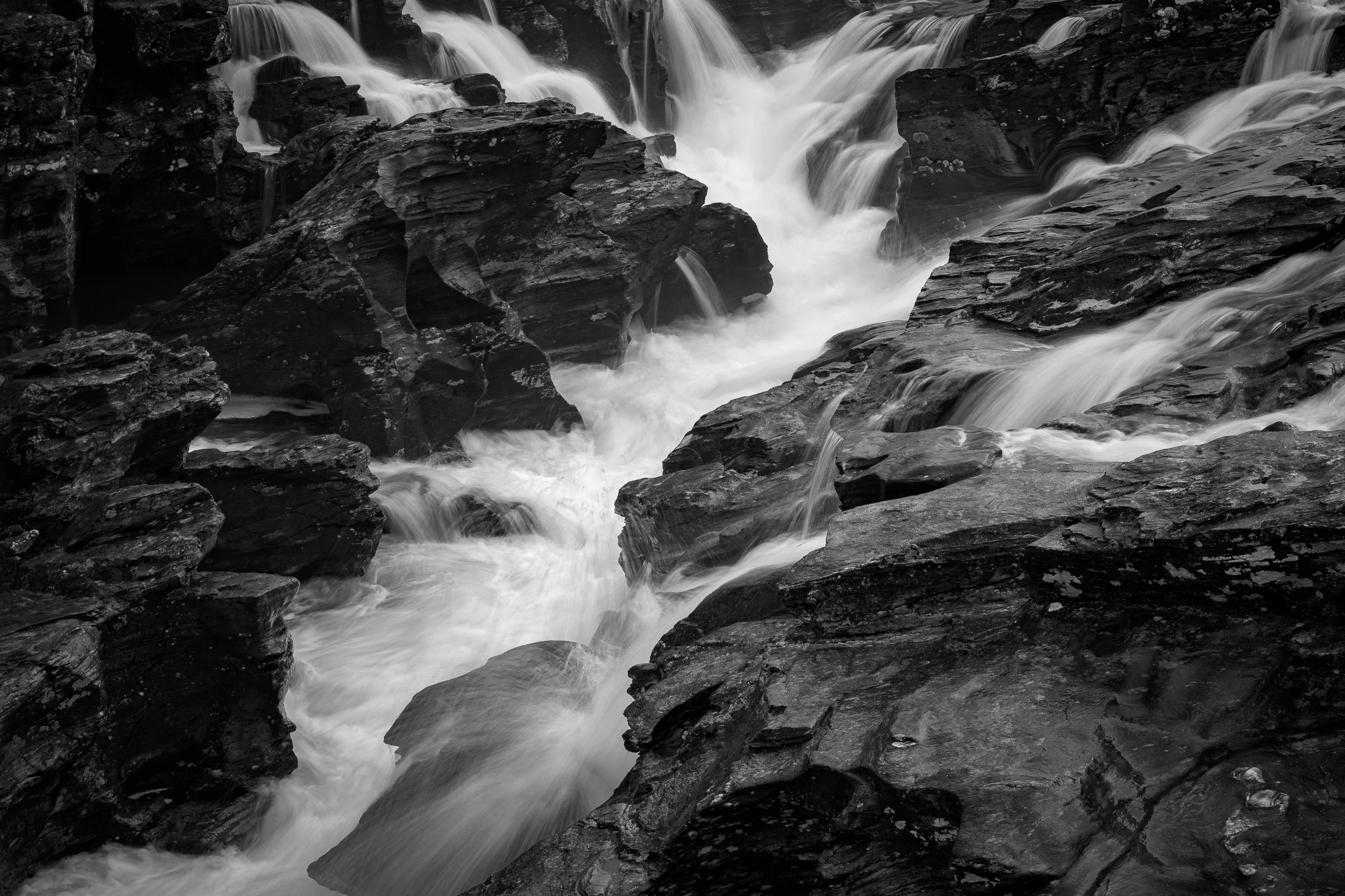 A high contrast black and white photograph of a waterfall in Glen Orchy in Scotland.