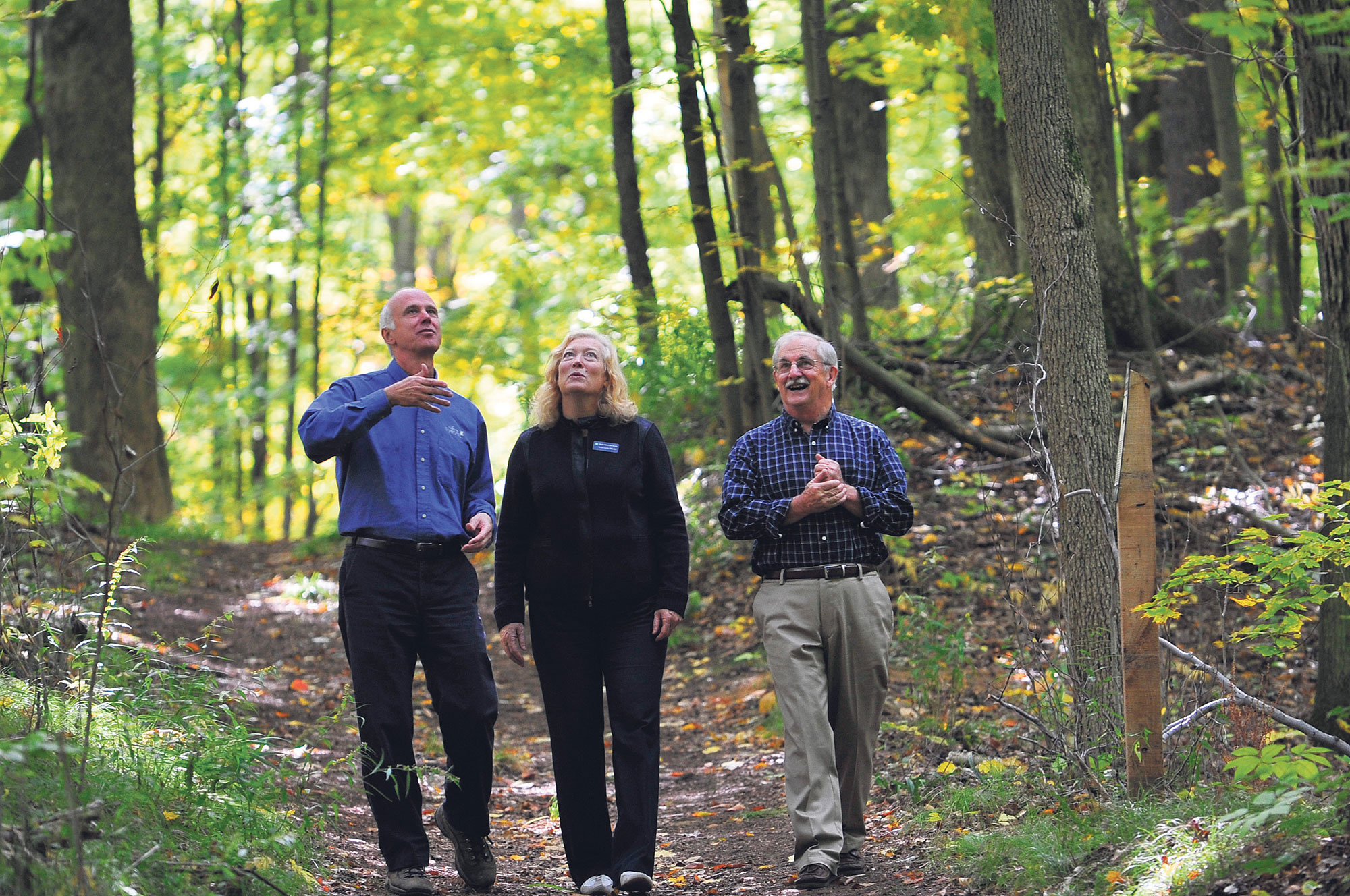 Paul Smith (right) takes a walk through the forest he transferred to NCC, with Karen Clarke-Whistler, chief environment officer of TD Bank Group, and John Lounds, NCC president and CEO. SIMON WILSON