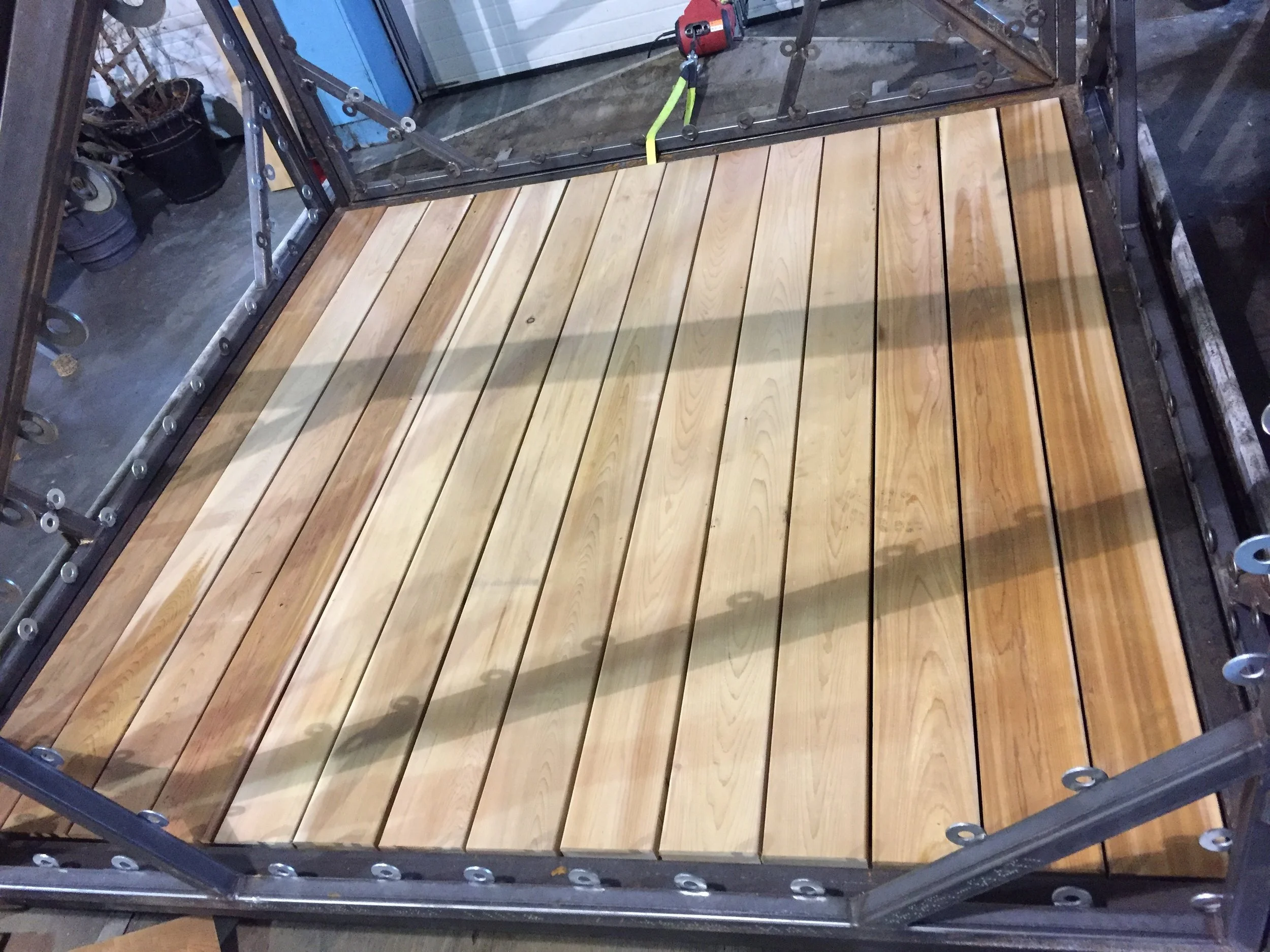 Like a glove!! The 2x6 cedar planks fit perfectly in the frame. Although this color scheme looks great, the floor boards will soon be stained black, and the frame will be white. Our goal is to have it look more approachable and less like the set of Mad Max.