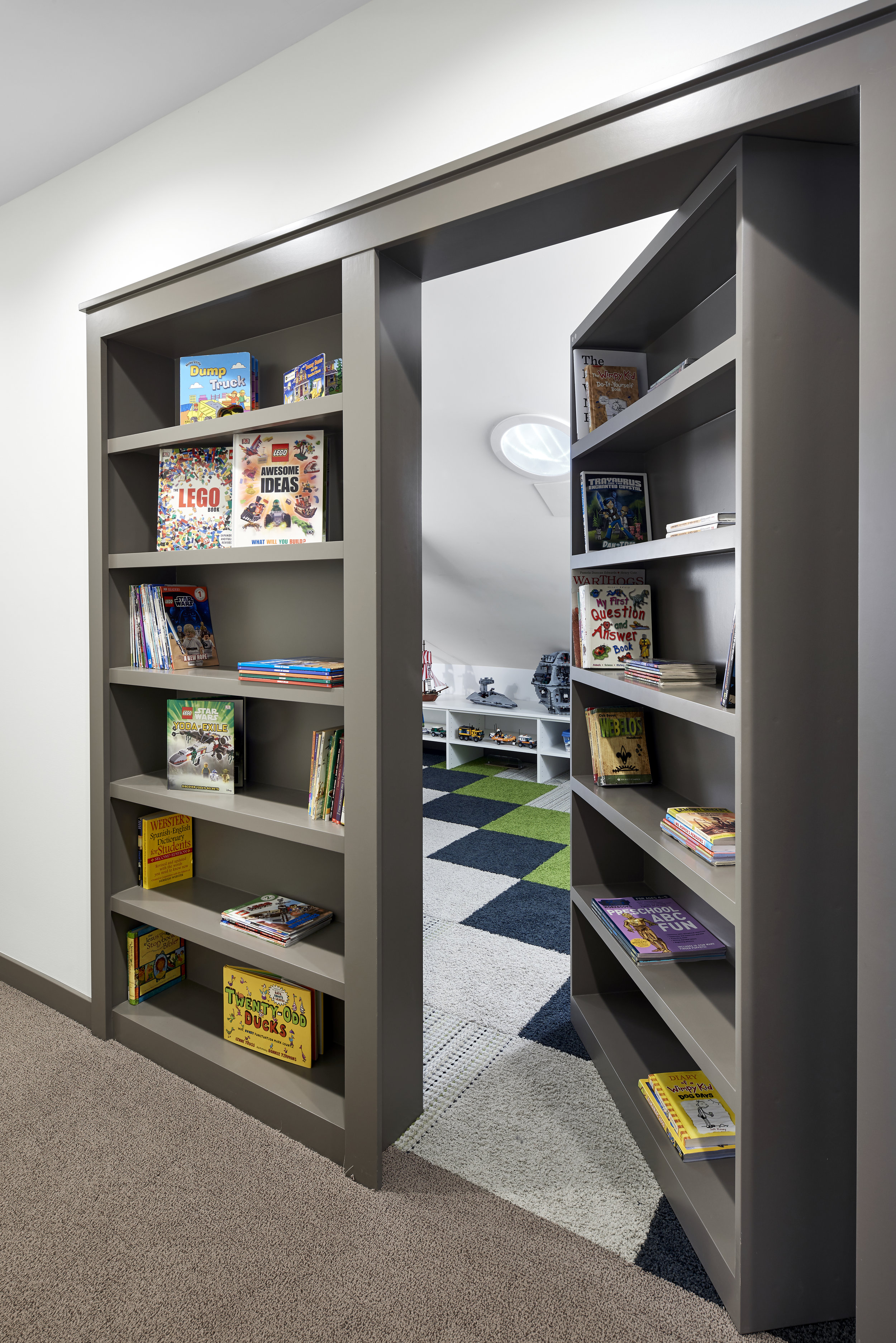 Toy room hidden behind bookcases, designed by NewStudio Architecture