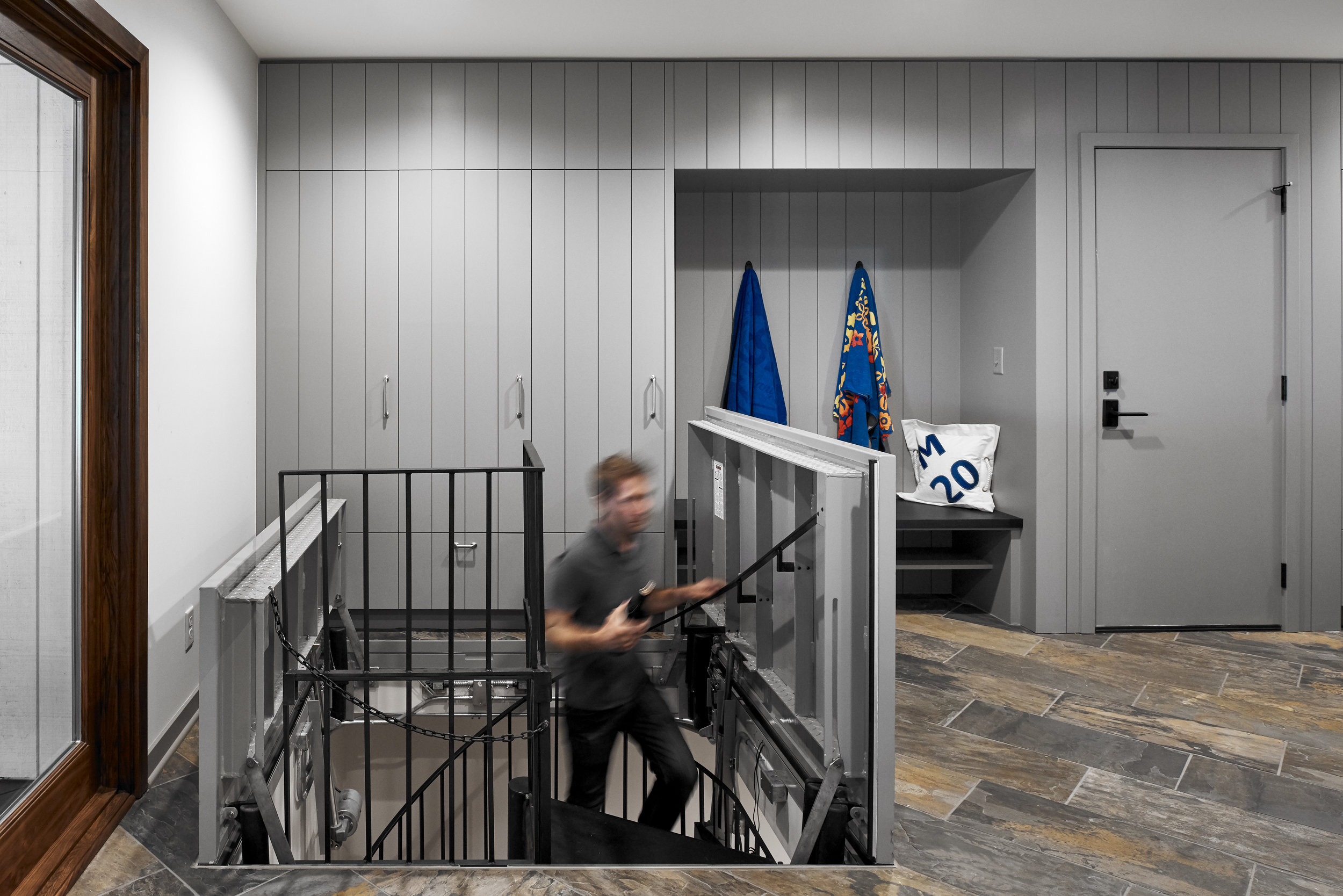 Spiral staircase leads to sailing team changing area, designed by NewStudio Architecture