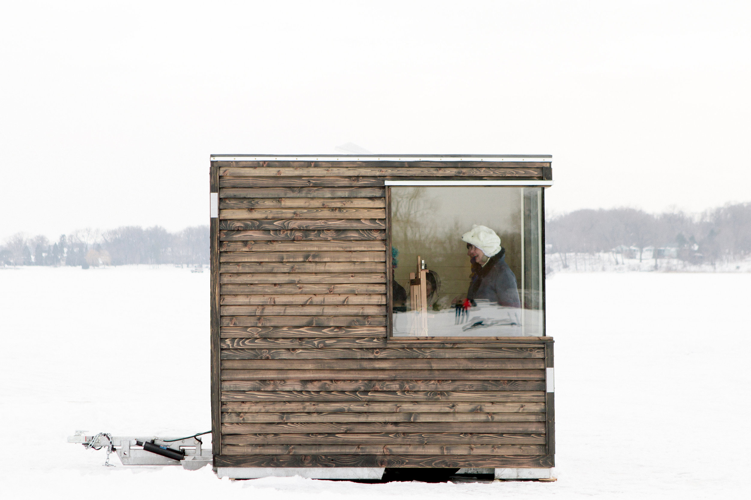 Exterior view shows an artist working inside the art shanty designed by NewStudio Architecture