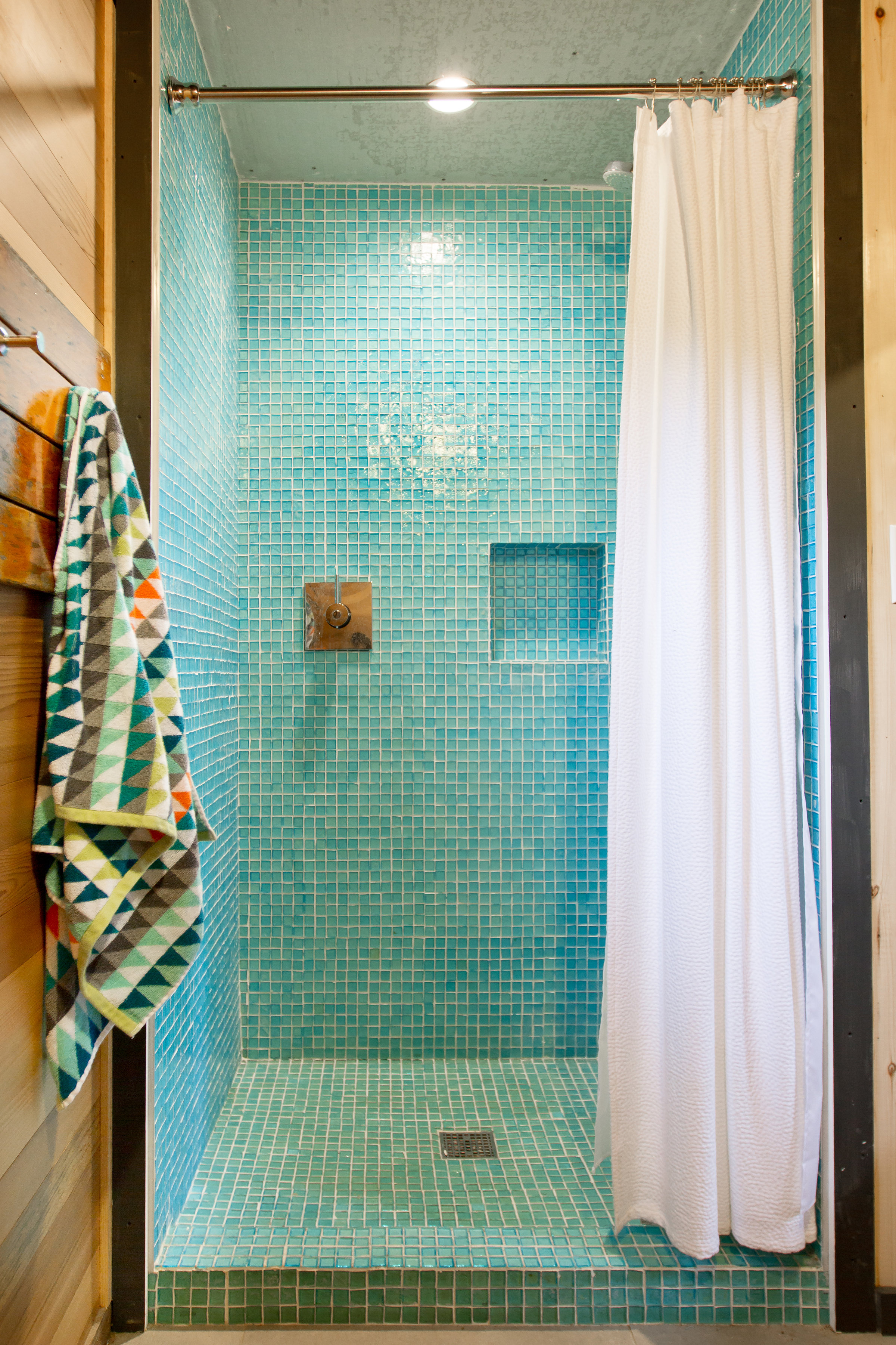 Aqua shower tile in mid-century modern boathouse designed by NewStudio Architecture