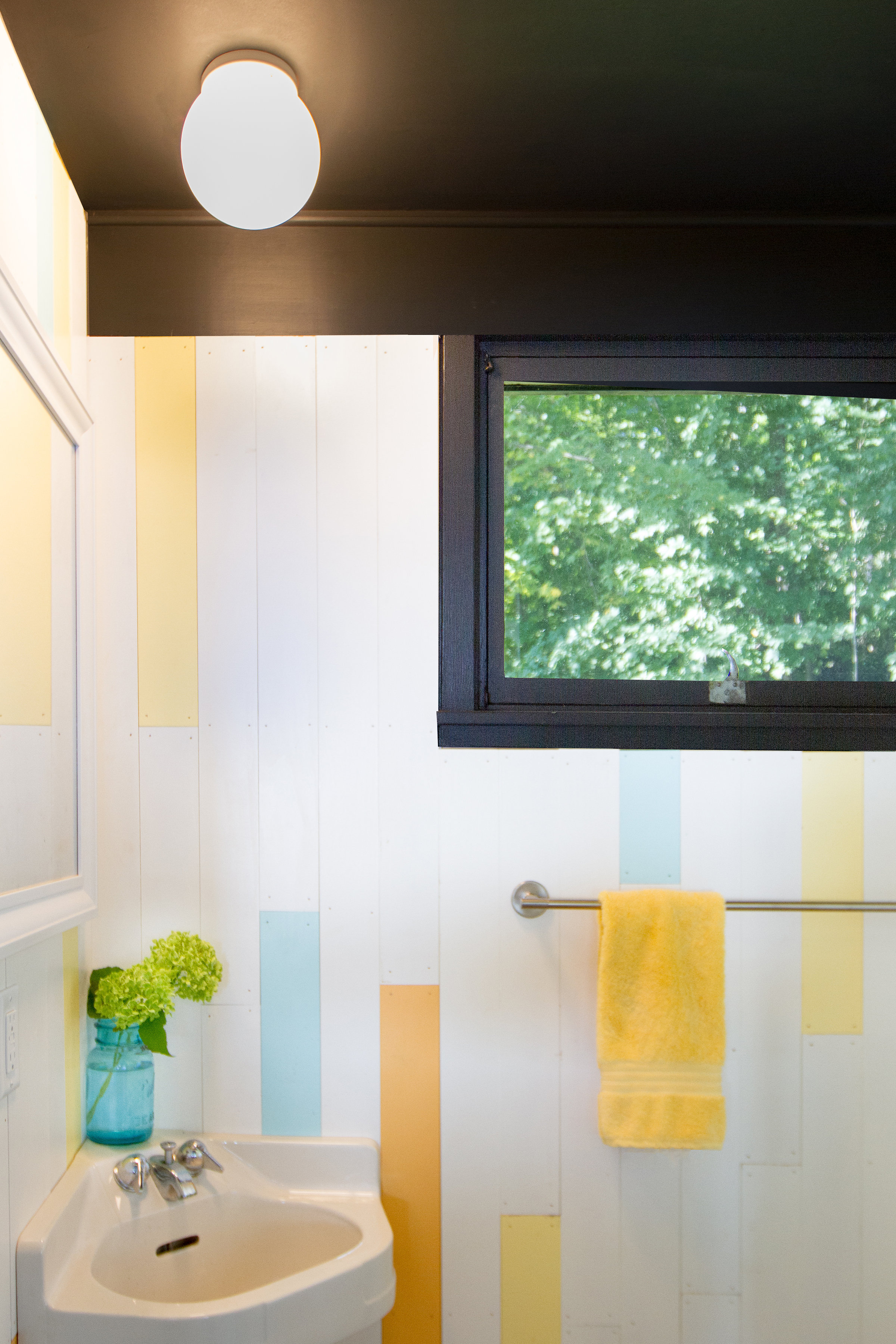 Charcoal trim contrasts white, aqua, yellow, and orange accents; designed by NewStudio Architecture