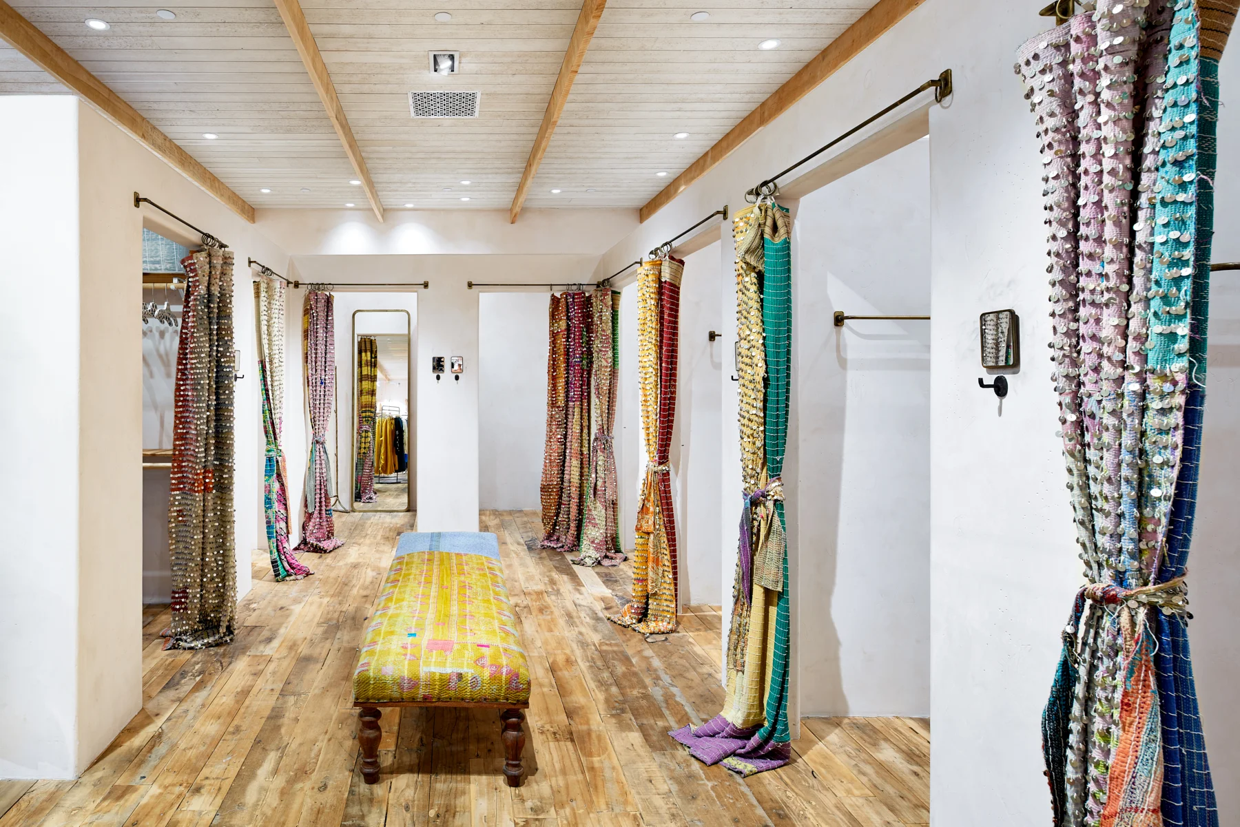 Rustic wood floor and bright curtains in fitting room area of Free People in Edina, Minnesota, created in collaboration with AOR NewStudio Architecture