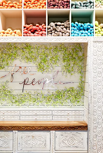 Color boxes top hand-carved wood at cashwrap in Free People at MOA