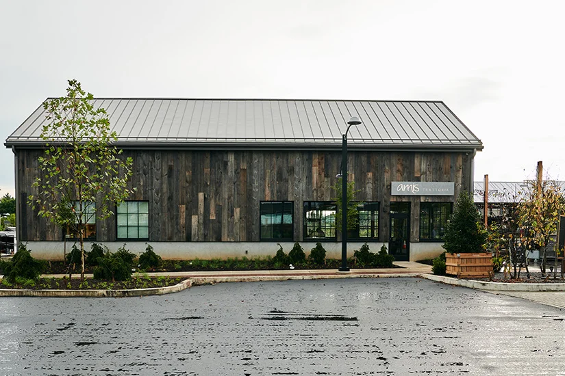 Reclaimed barn wood exterior reflects the sophisticated rustic ambiance of Amis Trattoria at Devon Yard