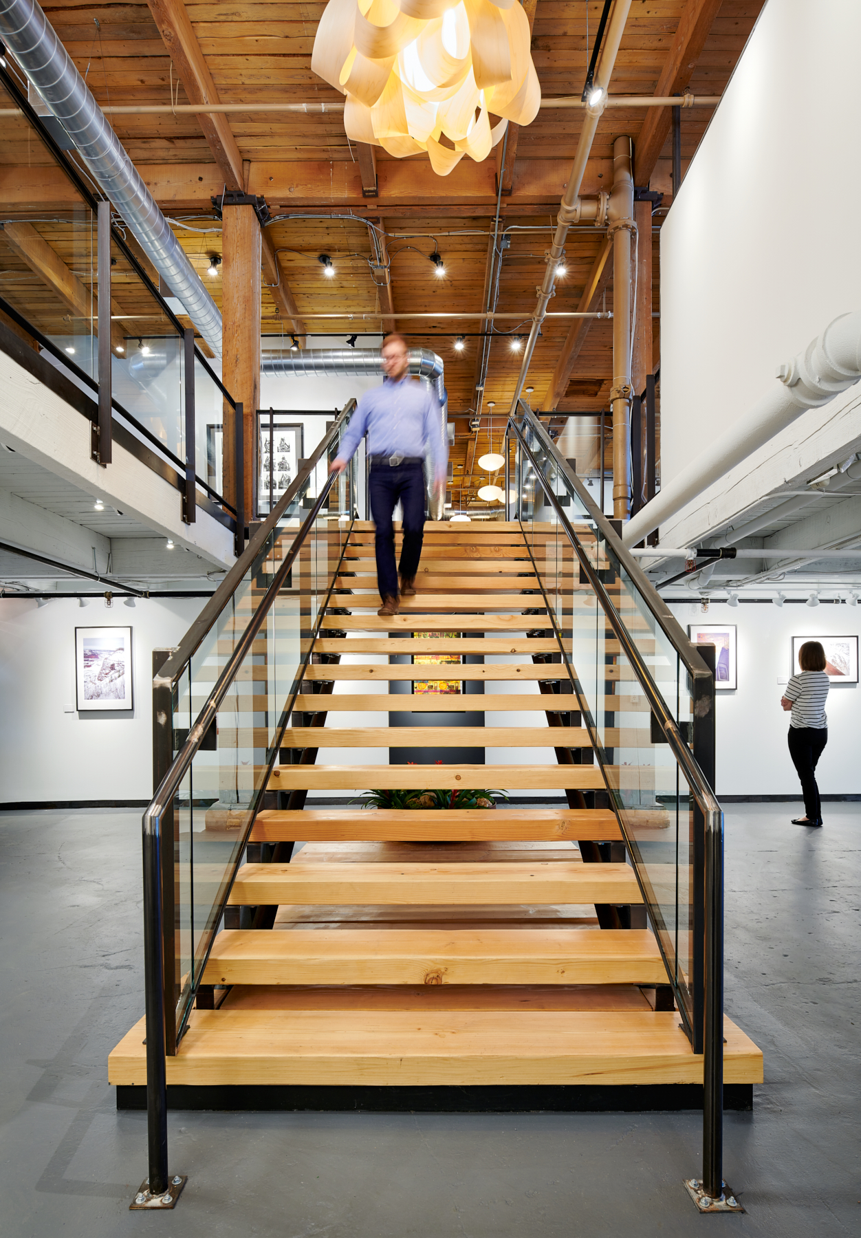 A custom steel and timber grand stair leads down to NewStudio Gallery at NewStudio Architecture's Saint Paul, Minnesota office.