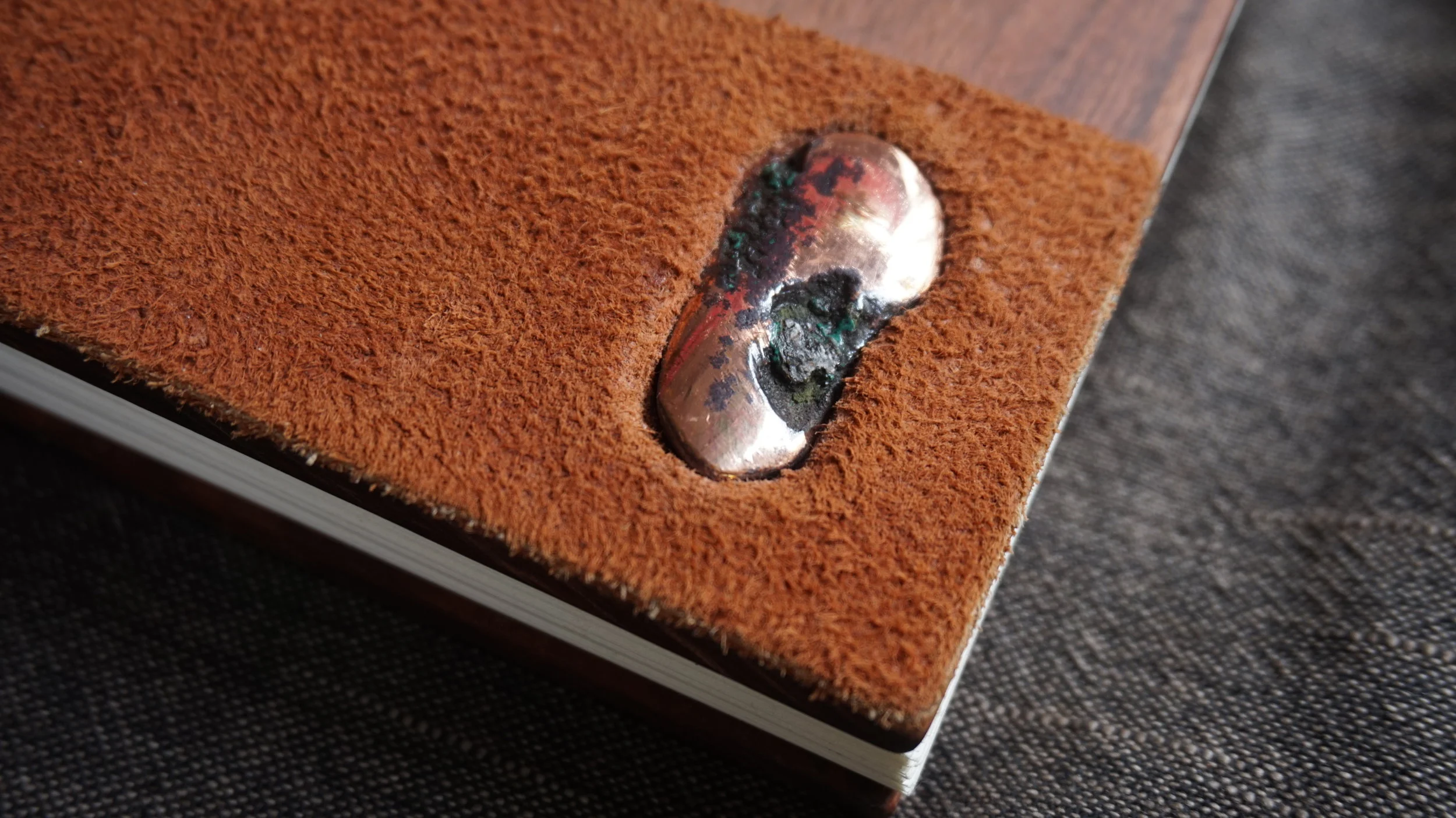 float copper set into rosewood and suede