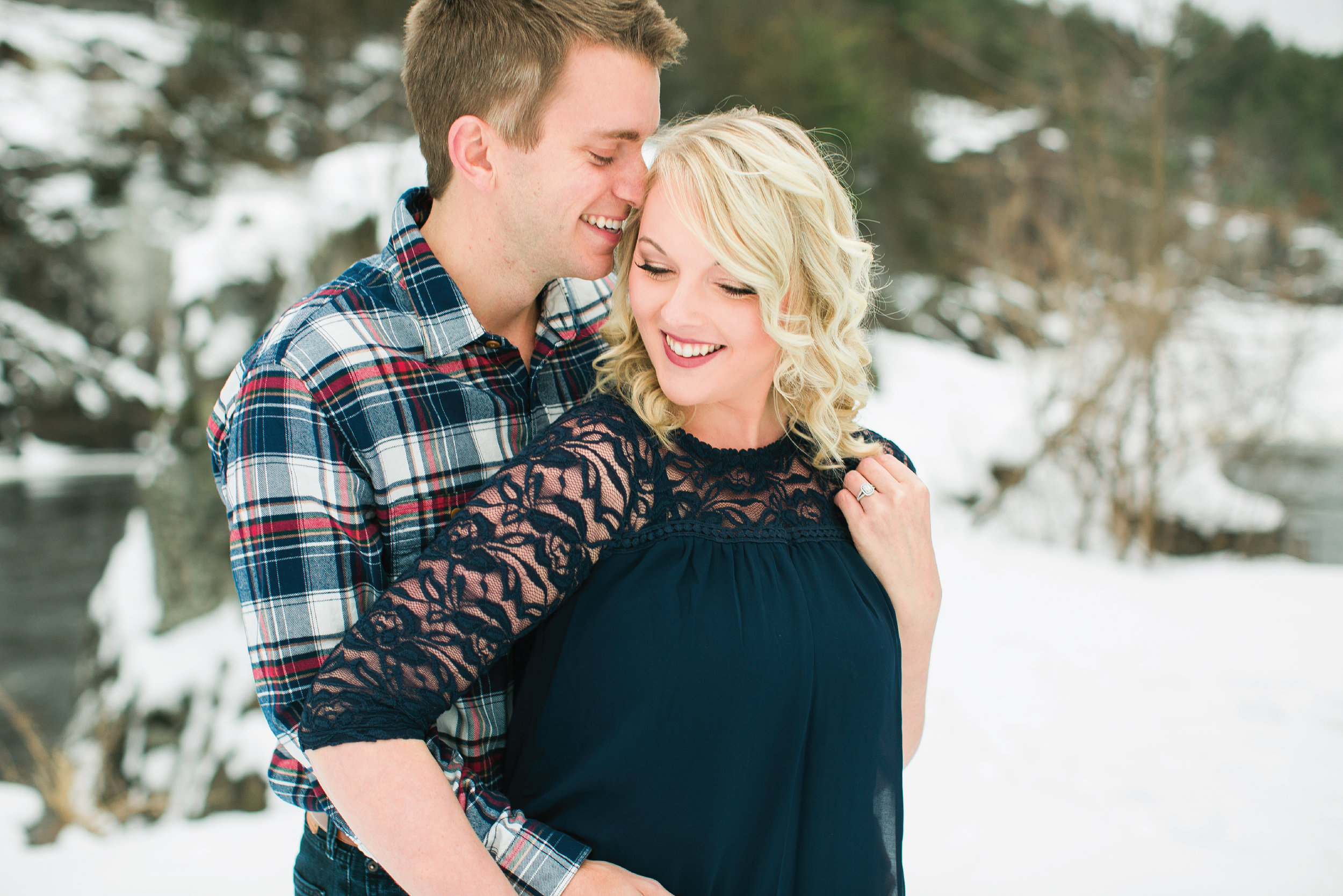 Minnesota snowy winter engagement photos in Taylors Falls Minnesota laughing in navy lace and plaid