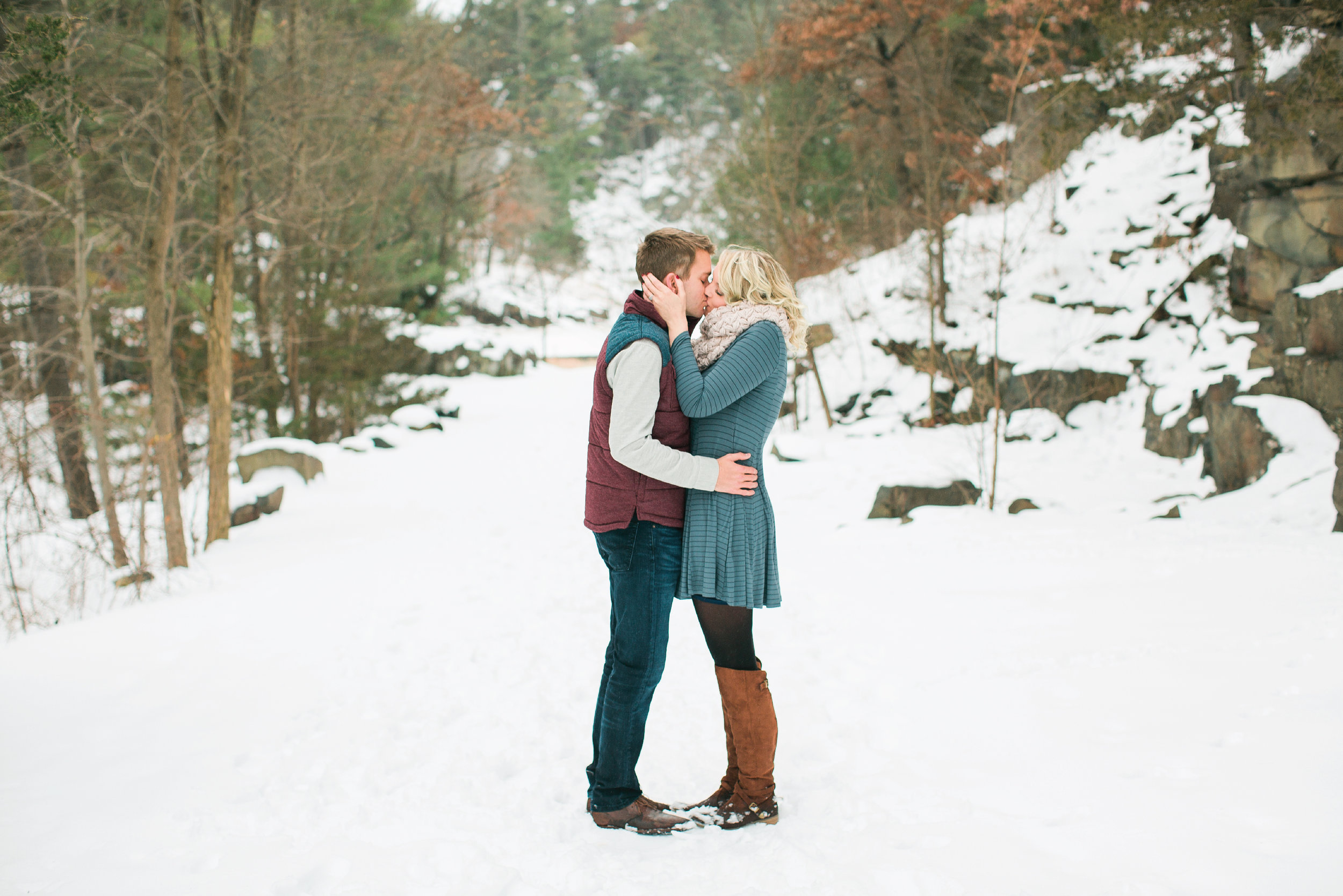 Taylors Falls Minnesota snowy winter engagement session in the woods with couple kissing