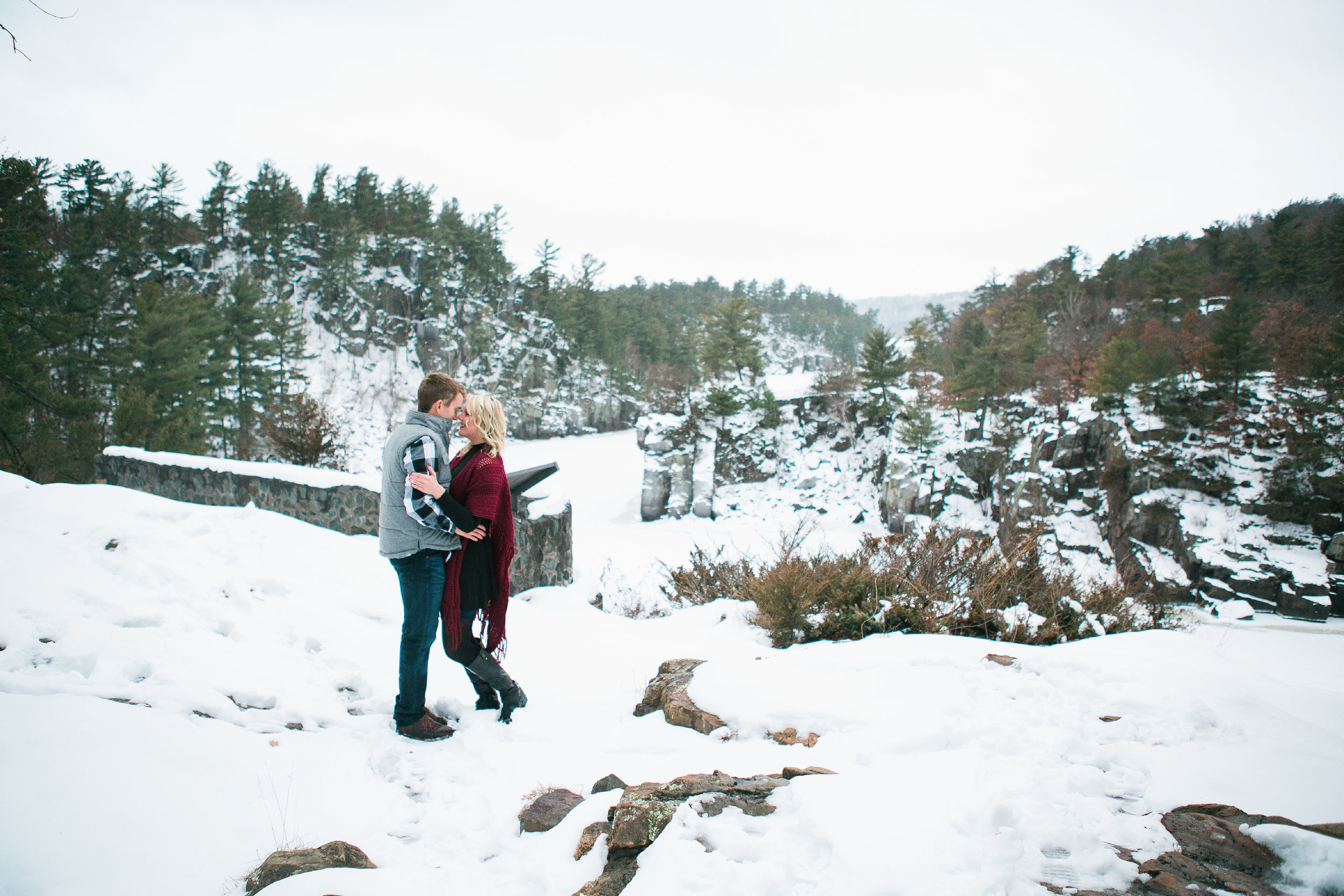 Snowy Minnesota Taylors Falls winter engagement photos on bluff overlooking river and woods