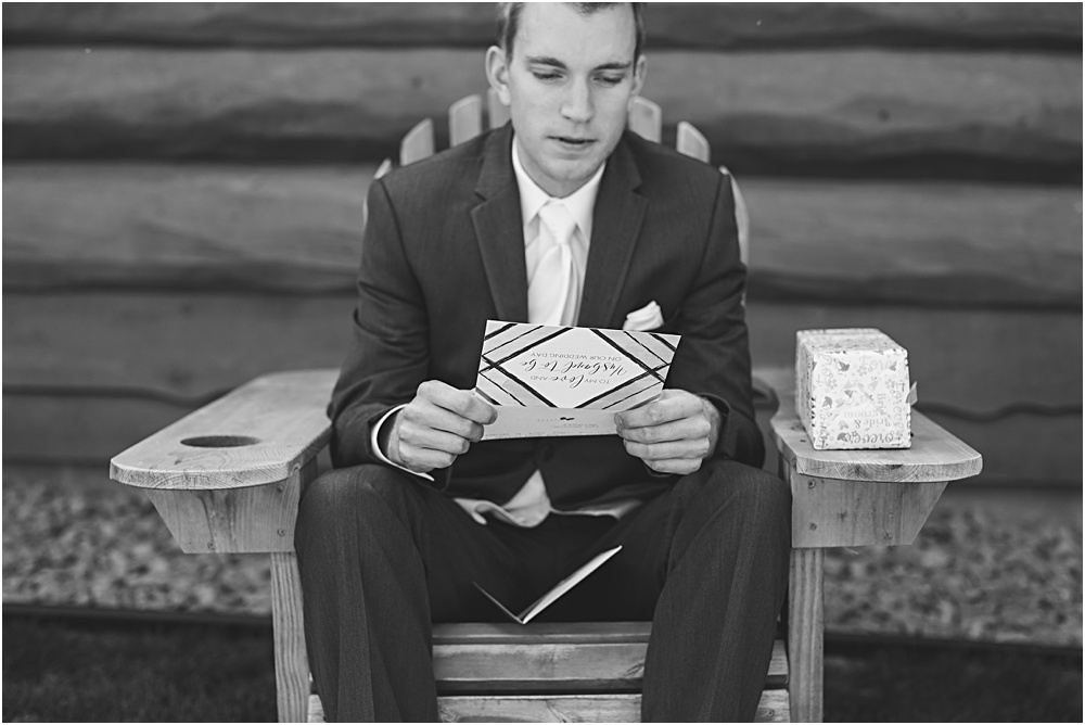 Groom reading letter from bride on wedding day during summer Minnesota wedding