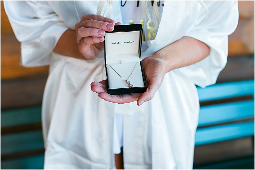 Minnesota summer wedding bride opening Fred Meyer Jewelry gift from groom in touching moment