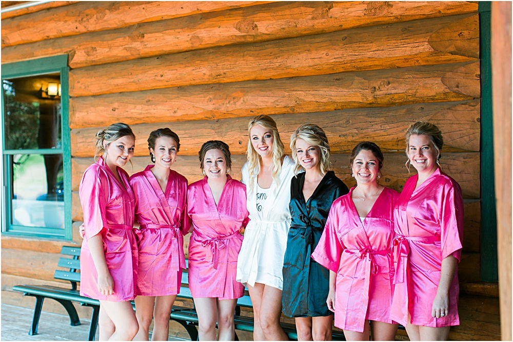 Minnesota summer wedding bride and bridesmaids in coordinating pink robes in front of cabin
