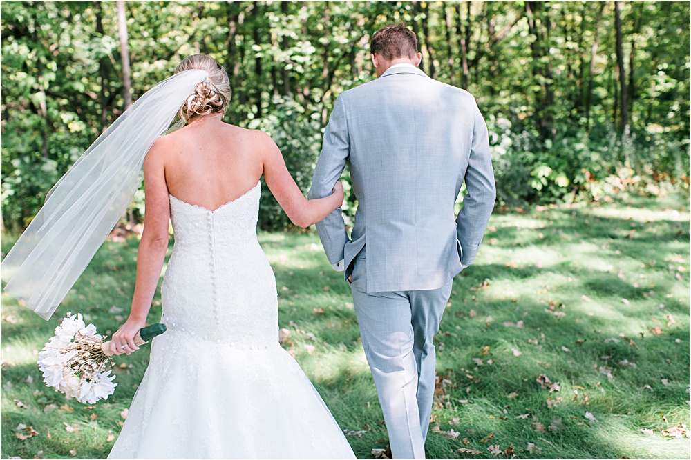 Bride and groom walking outside at Minnesota summer wedding in Buffalo MN photographed by Mallory Kiesow, Minnesota wedding photographer