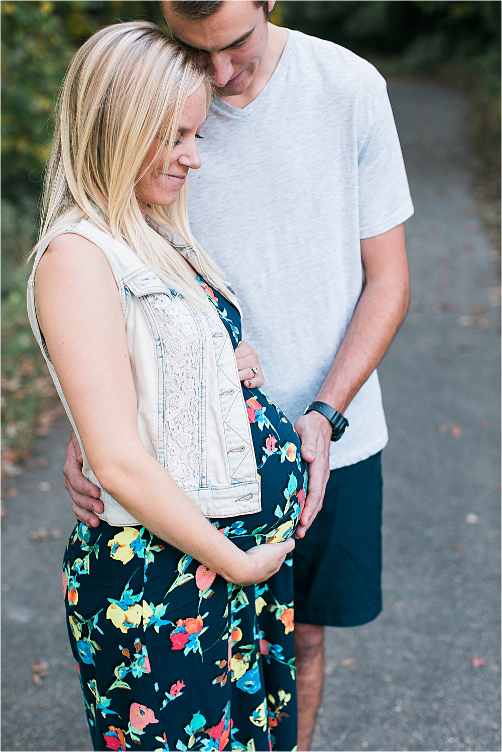 Husband and wife holding bump for Minnesota fall maternity photos