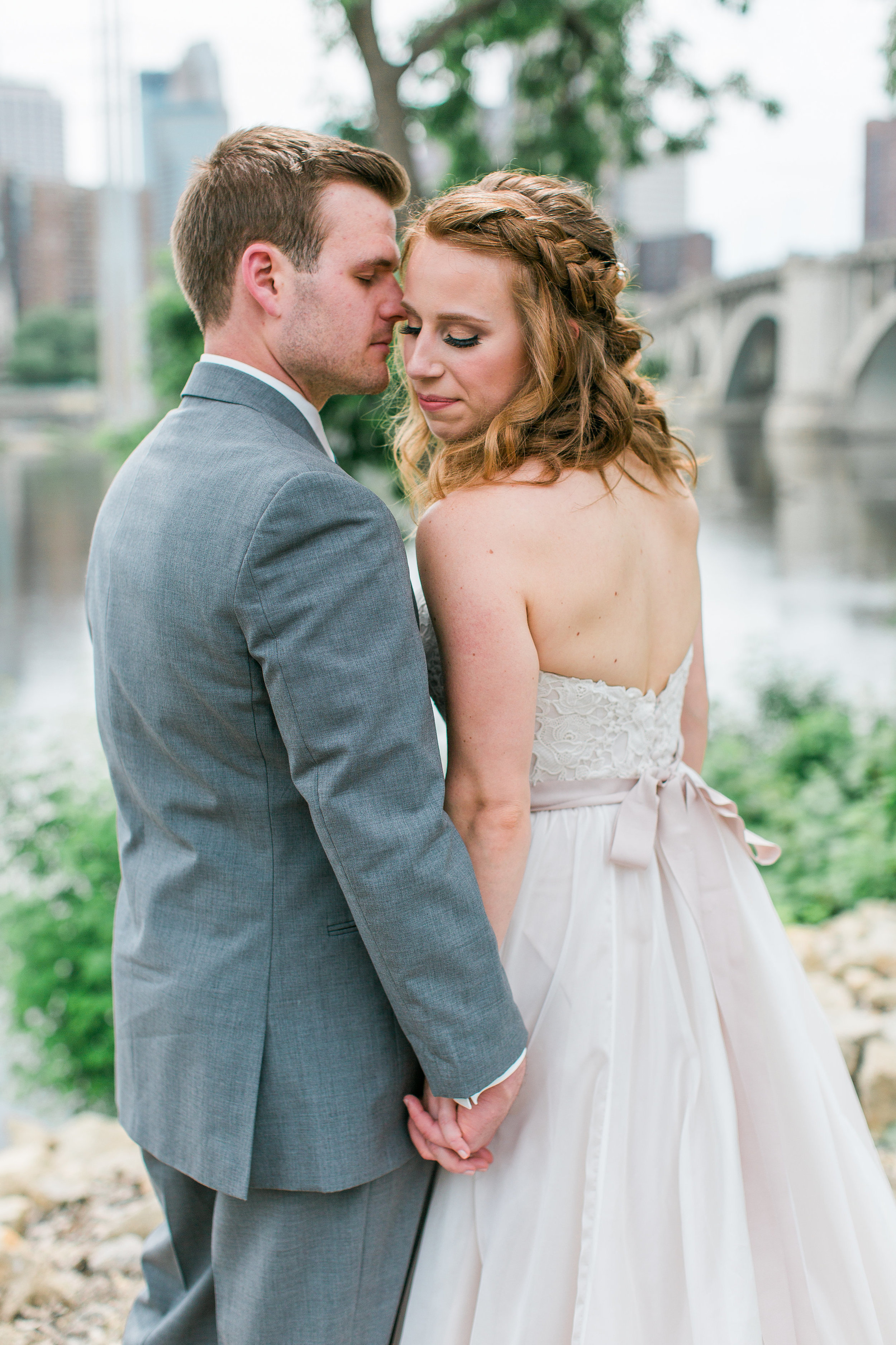 Minneapolis Event Centers bride and groom portrait with Minneapolis bridge and skyline in background Minnesota wedding photography Mallory Kiesow Photography