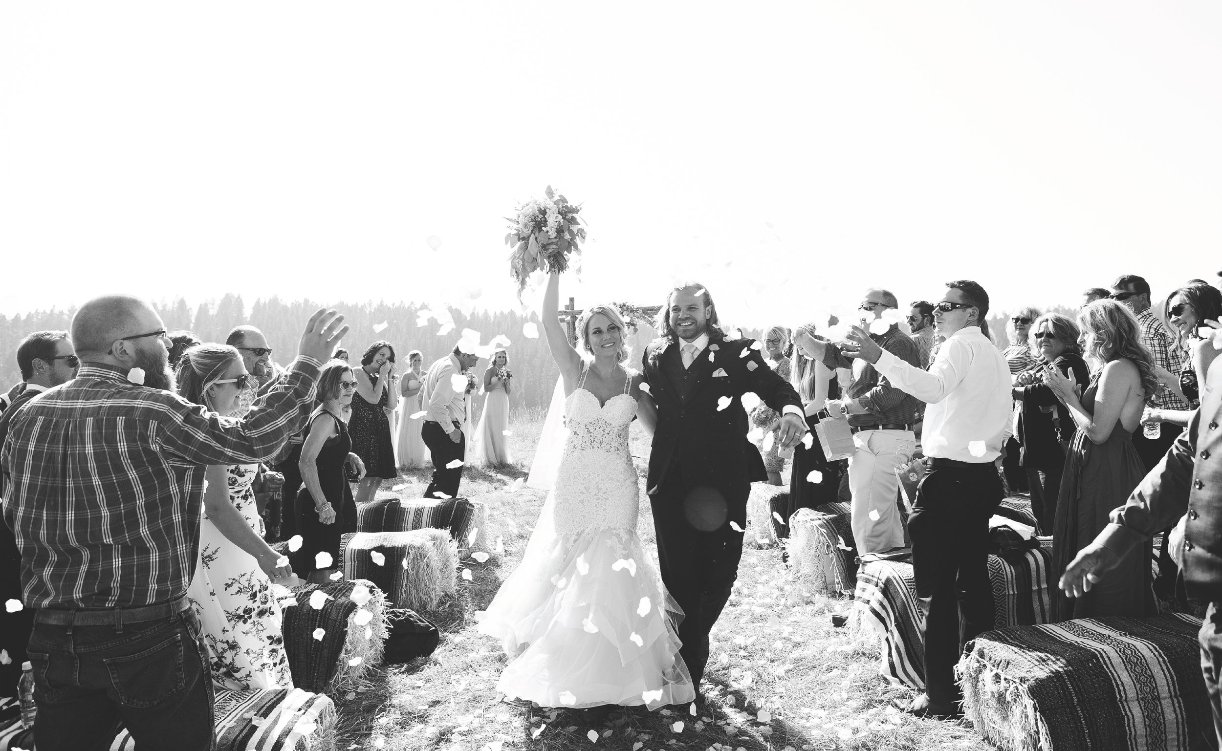 Bride and groom exiting ceremony celebrating with confetti black and white mountainside Montana wedding Lone Mountain Ranch Minnesota wedding photographer Mallory Kiesow Photographhy