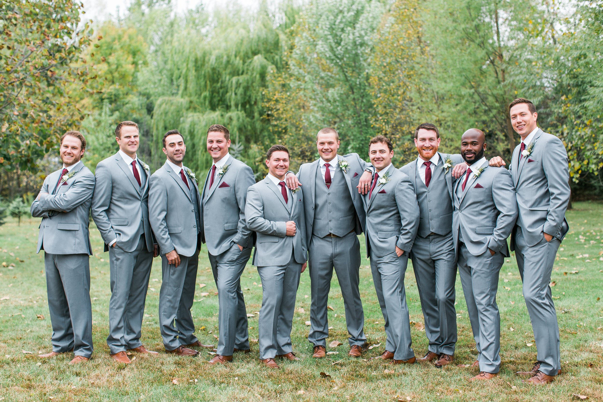 Groomsmen in gray suits with burgundy accents casual pose Minnesota backyard fall wedding Minnesota wedding photography Mallory Kiesow Photography