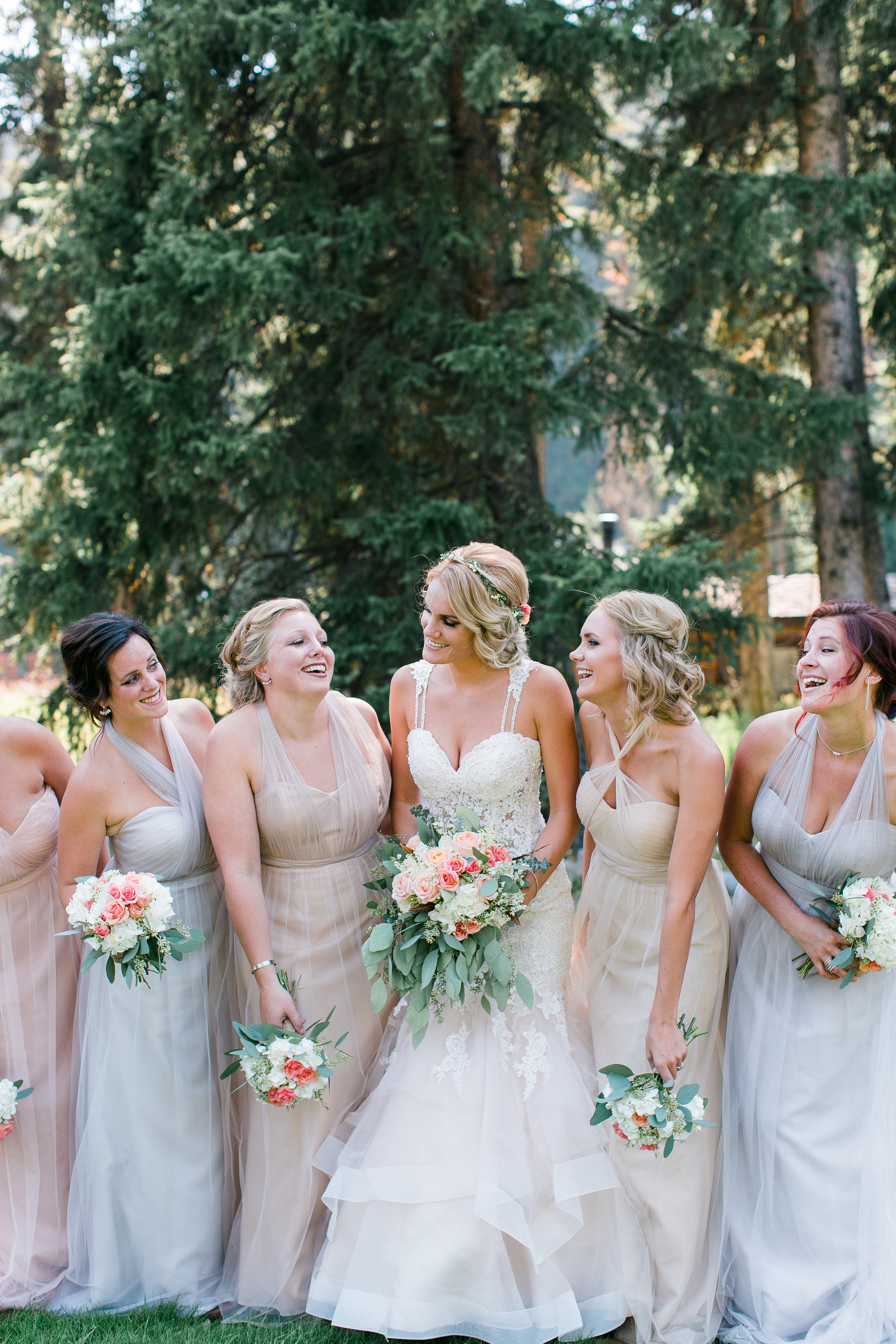 Boho bride with bridesmaids in neutral dresses with bouquets laughing Montana Big Sky Lone Mountain Ranch wedding Minnesota wedding photography Mallory Kiesow Photography