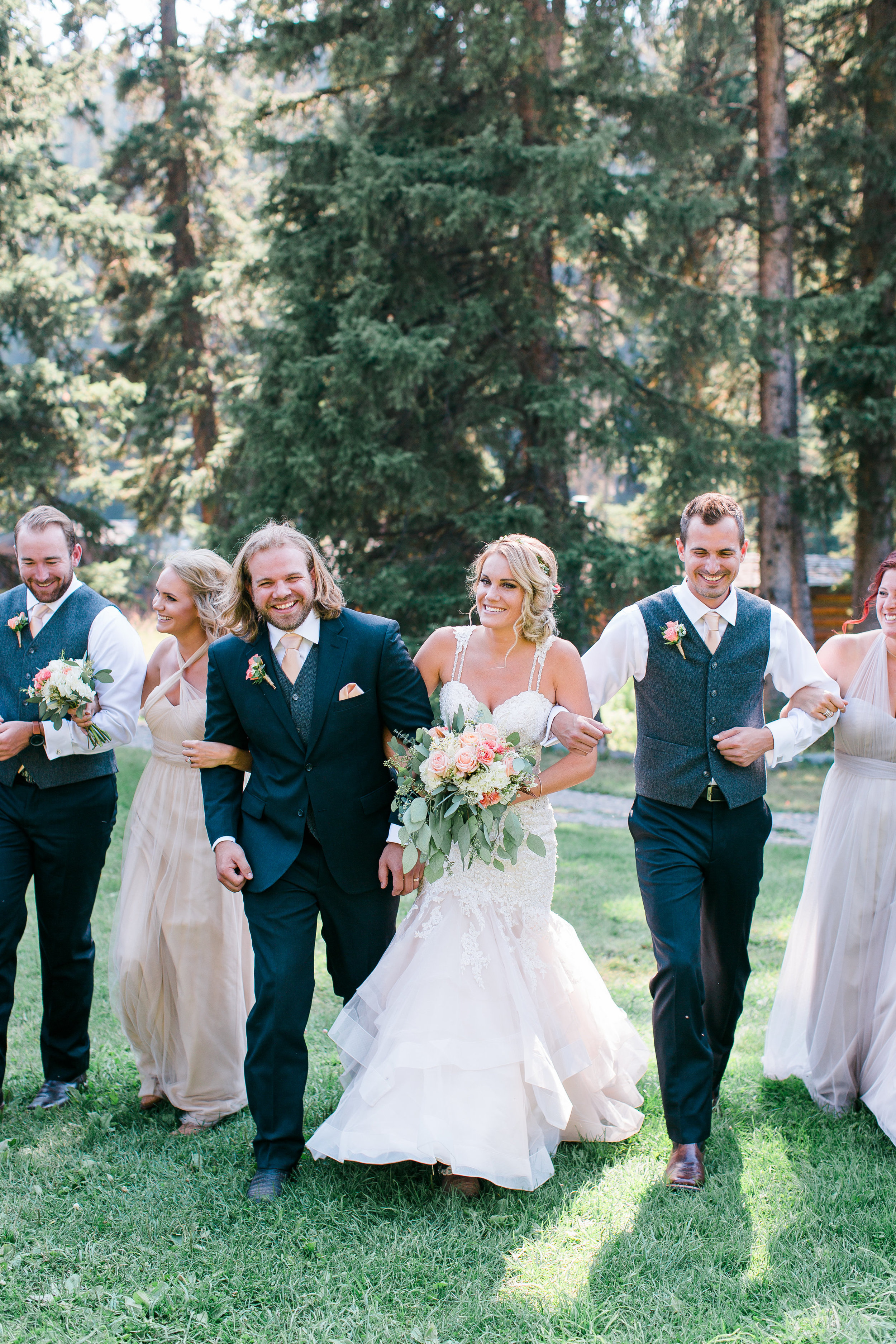 Wedding party with black suits and neutral bridesmaid dresses walking and laughing Big Sky Montana Lone Mountain Ranch wedding Minnesota wedding photography Mallory Kiesow Photography